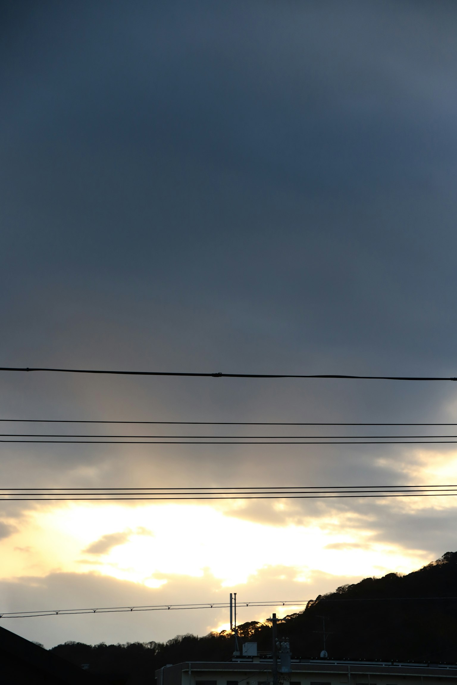 Eine Landschaft mit Sonnenlicht, das durch dunkle Wolken bricht