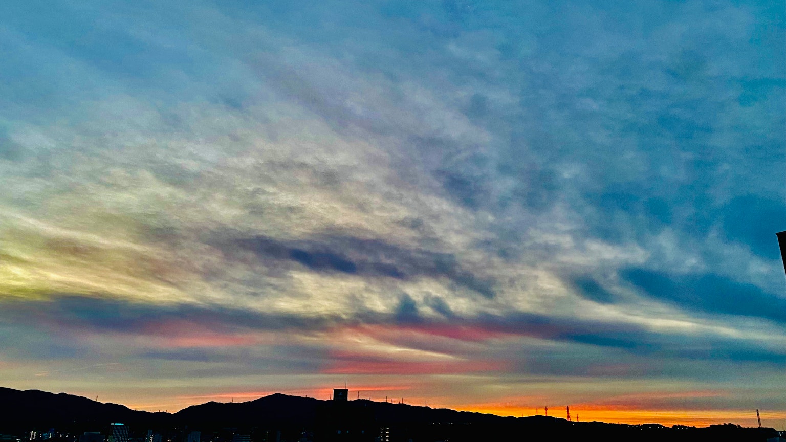 Cielo al tramonto colorato con silhouette di montagne
