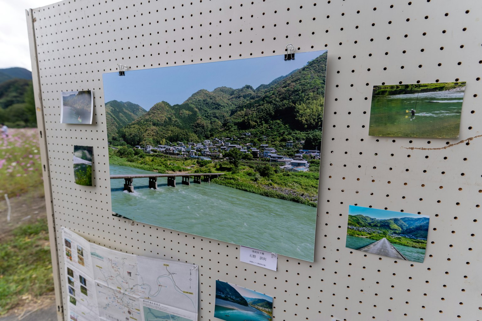 展示板上展示了一个被山脉环绕的村庄和蓝色河流的风景