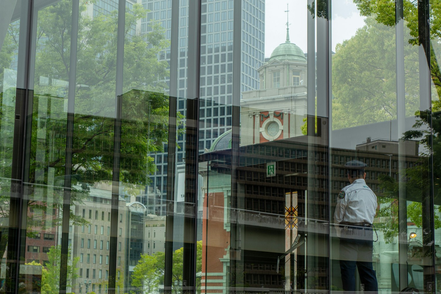 玻璃建筑中时钟塔和城市景观的倒影