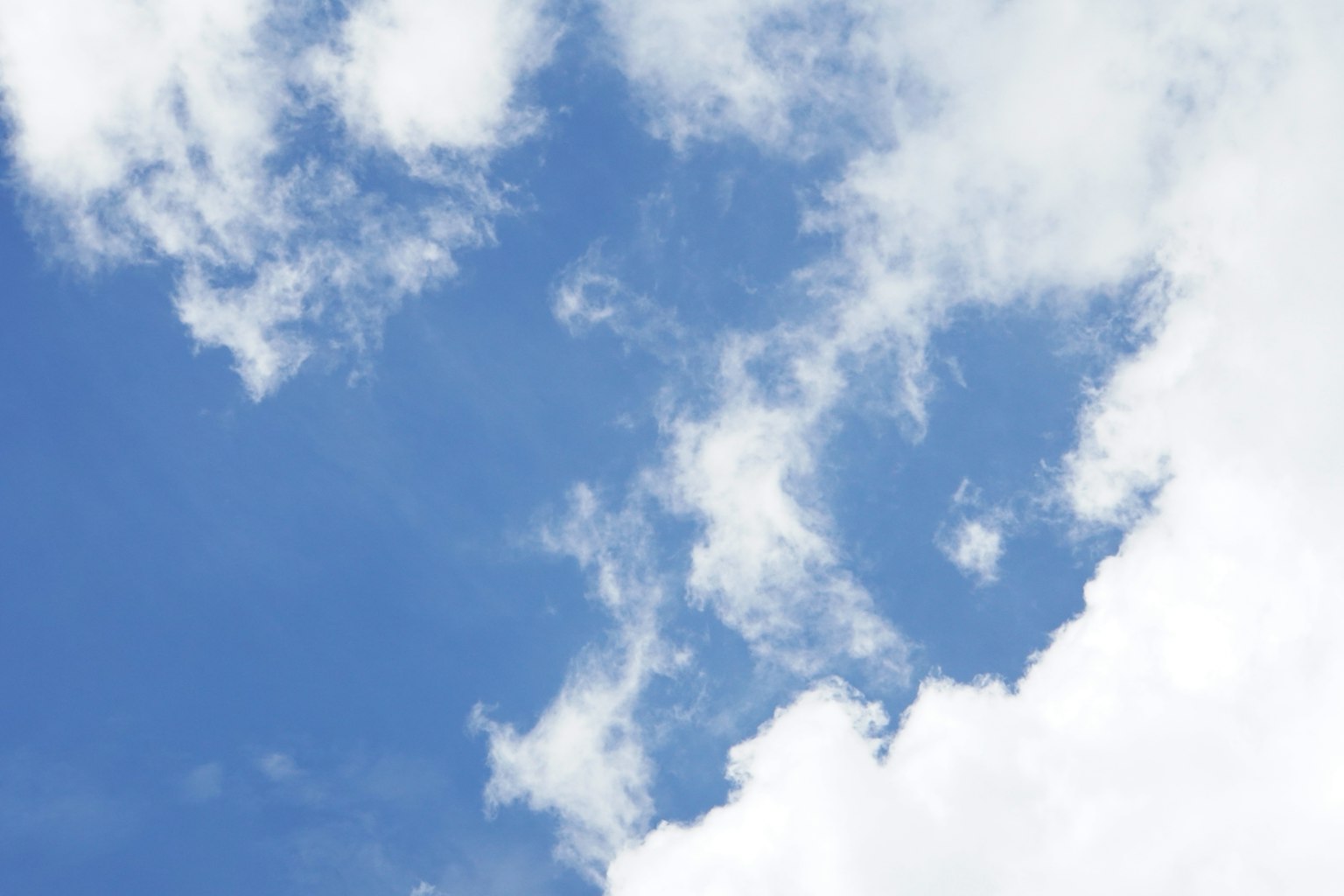 Ein blauer Himmel mit flauschigen weißen Wolken