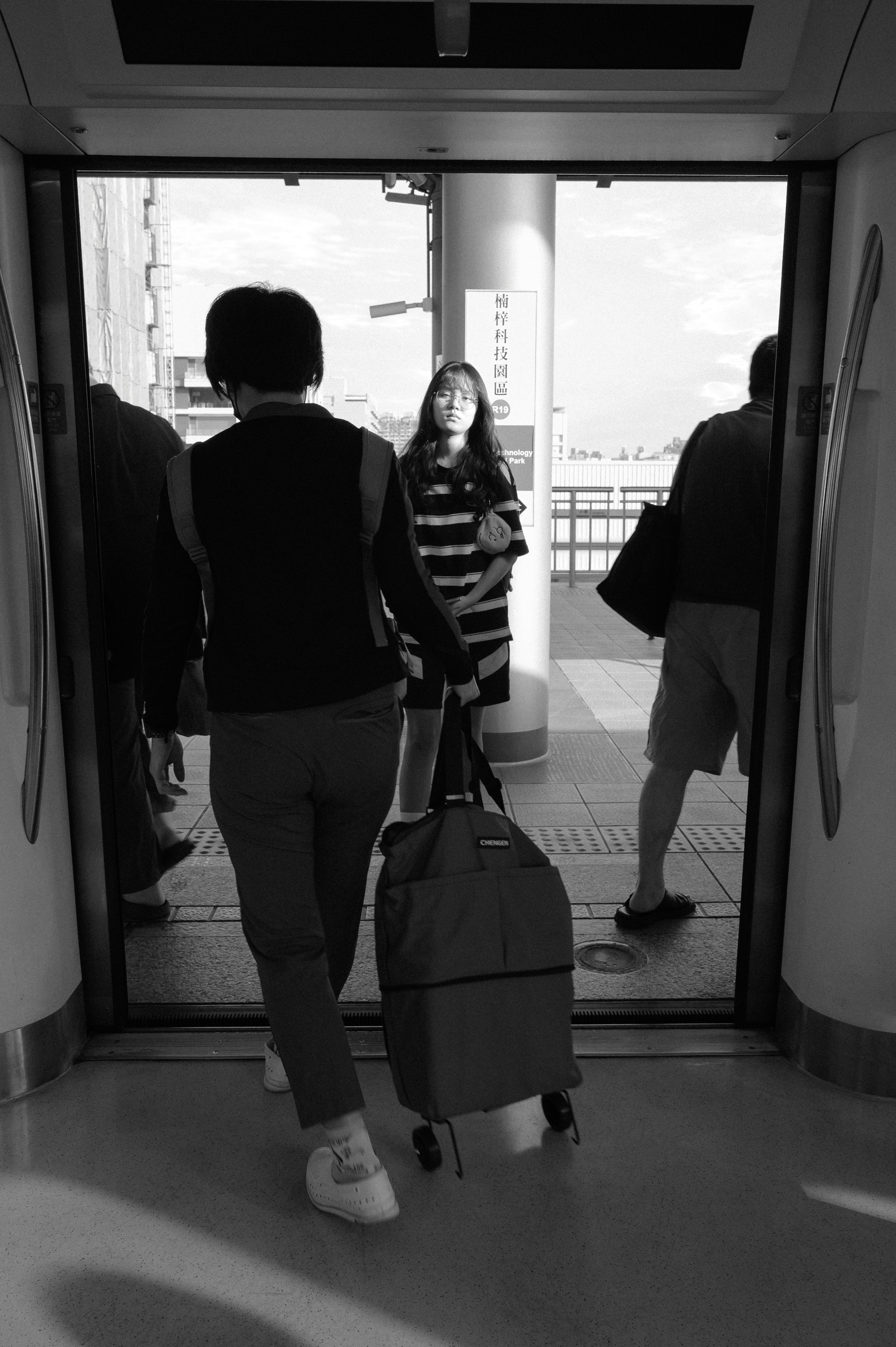 people walking through a station gate with suitcases