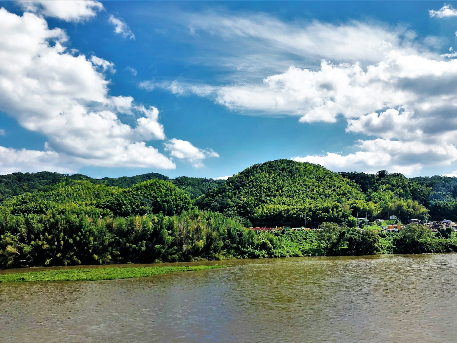 Pemandangan indah dengan langit biru dan awan putih bukit hijau dan sungai