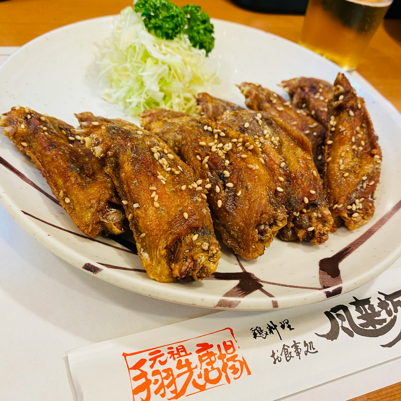盘子里的鸡翅，撒上芝麻和切好的卷心菜