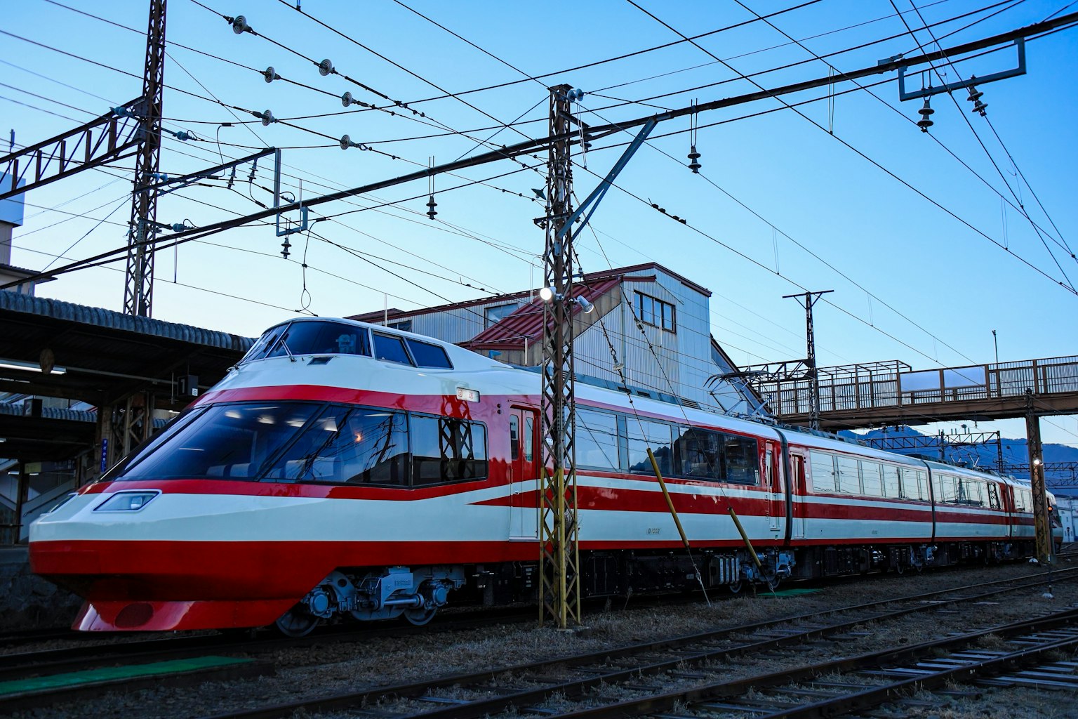 Tren expreso con diseño rojo y blanco estacionado en la estación