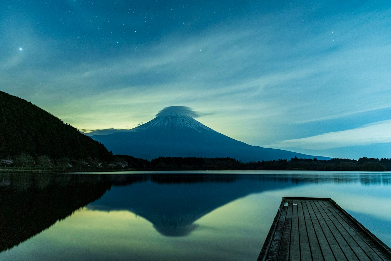 富士山在星空下的宁静湖泊中倒影