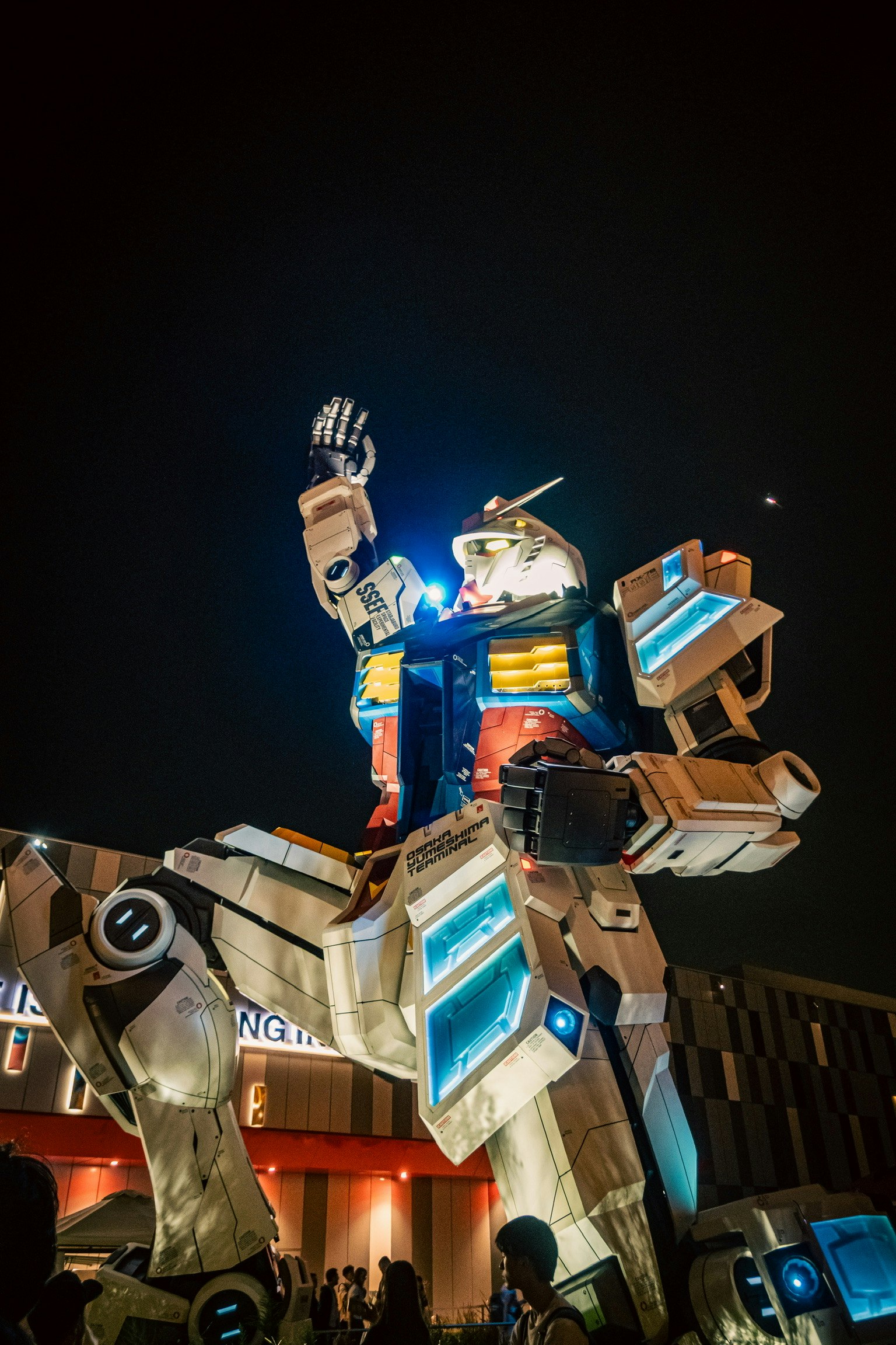 夜のガンダム像が光を放ちながら立っている様子