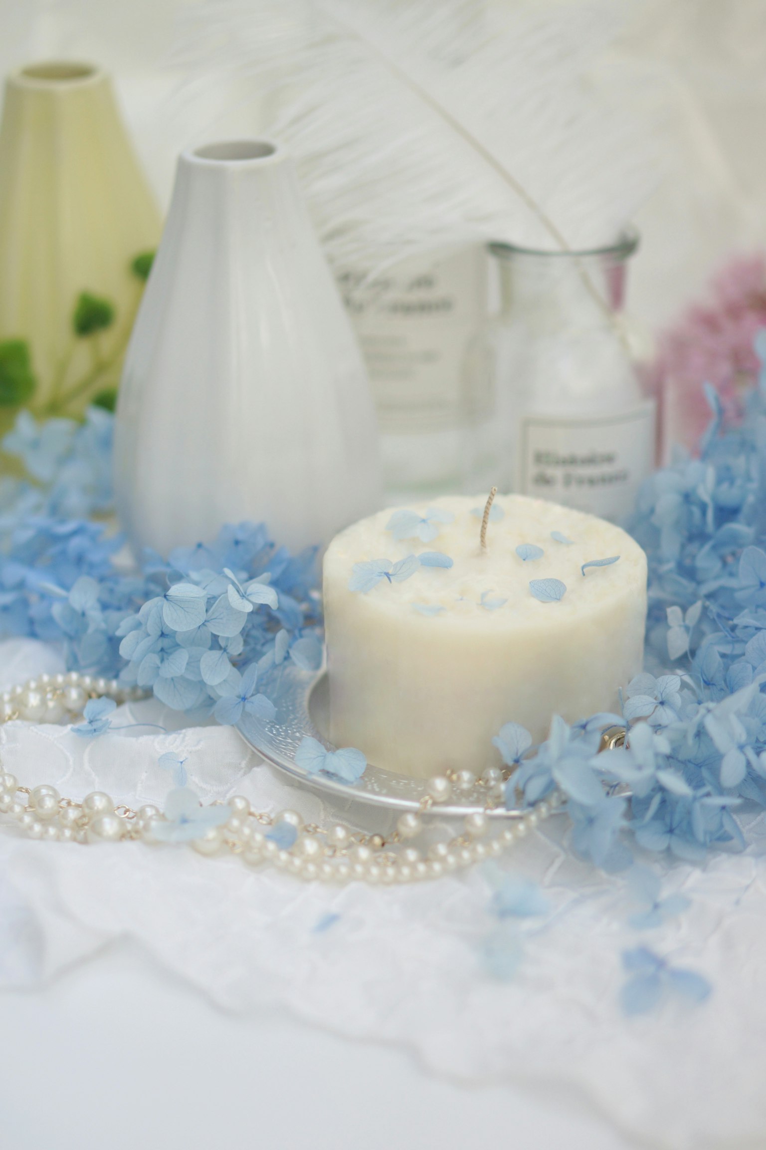 Elegant table setting featuring blue petals and a white candle