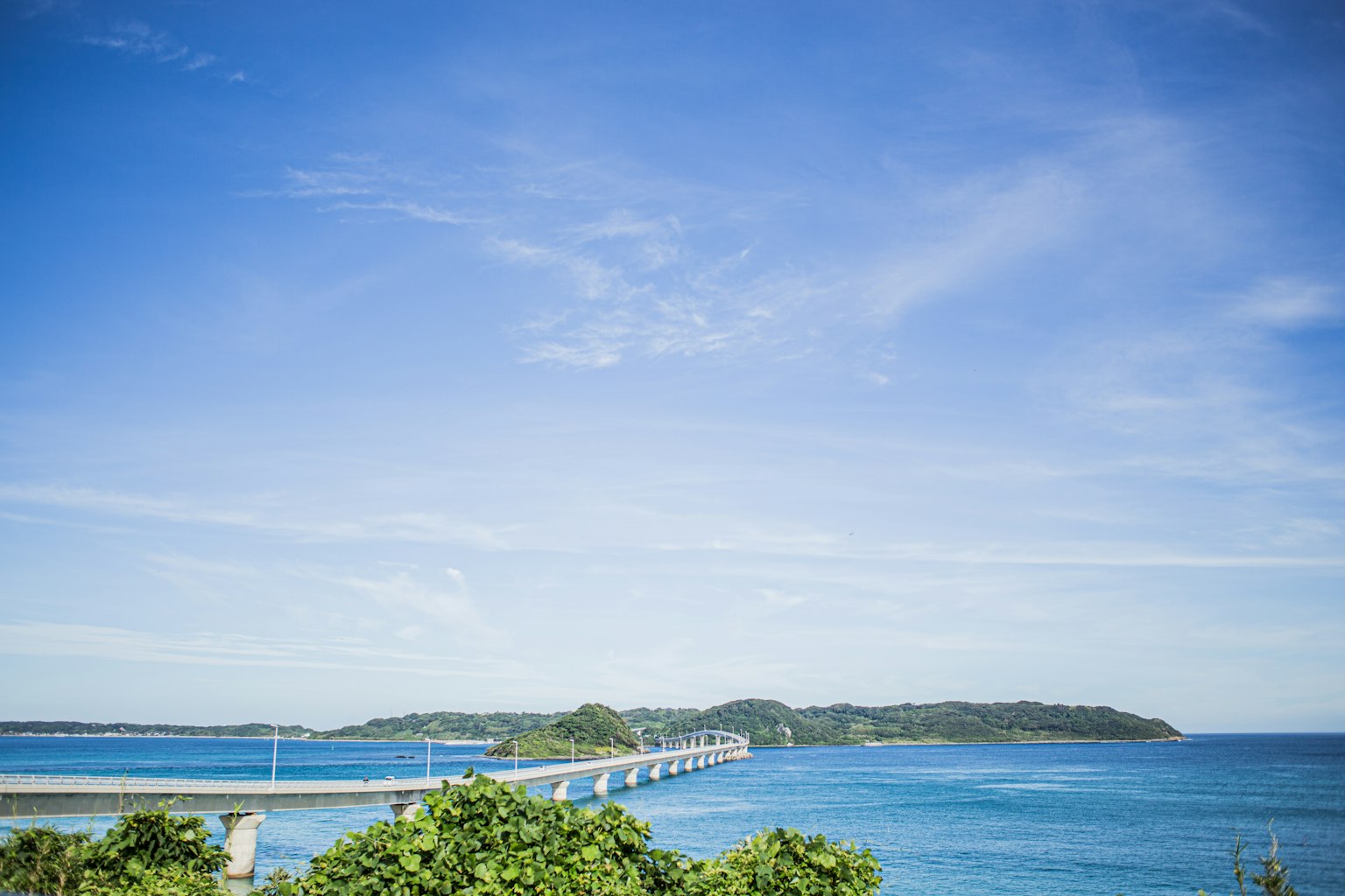 Una vista escénica de un puente que lleva a una isla bajo un cielo azul claro