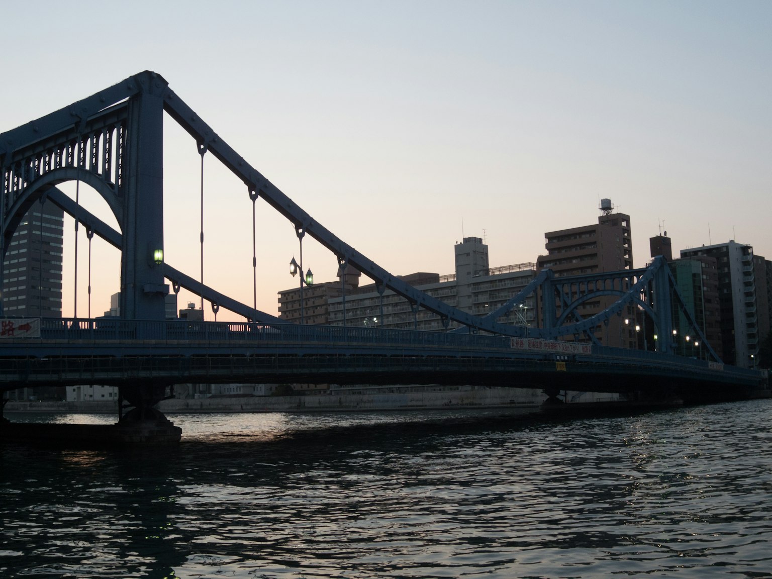Pont bleu au crépuscule avec skyline urbain