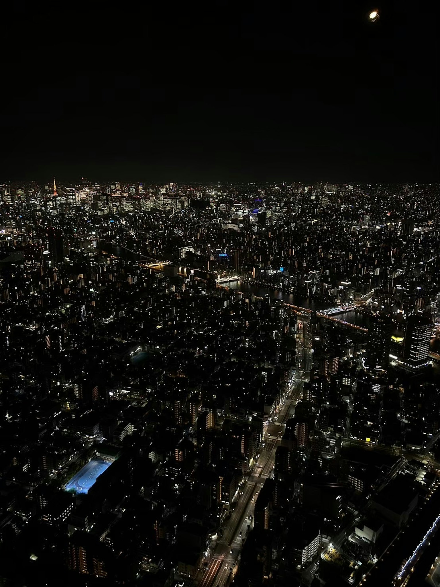 ทิวทัศน์พาโนรามาของเส้นขอบฟ้าของโตเกียวในตอนกลางคืนพร้อมอาคารที่มีแสงสว่าง