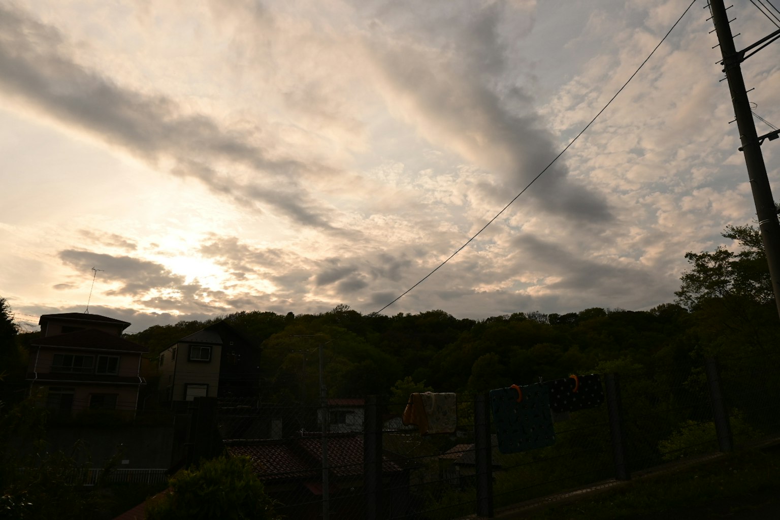 Cielo al atardecer con nubes dispersas y siluetas de árboles