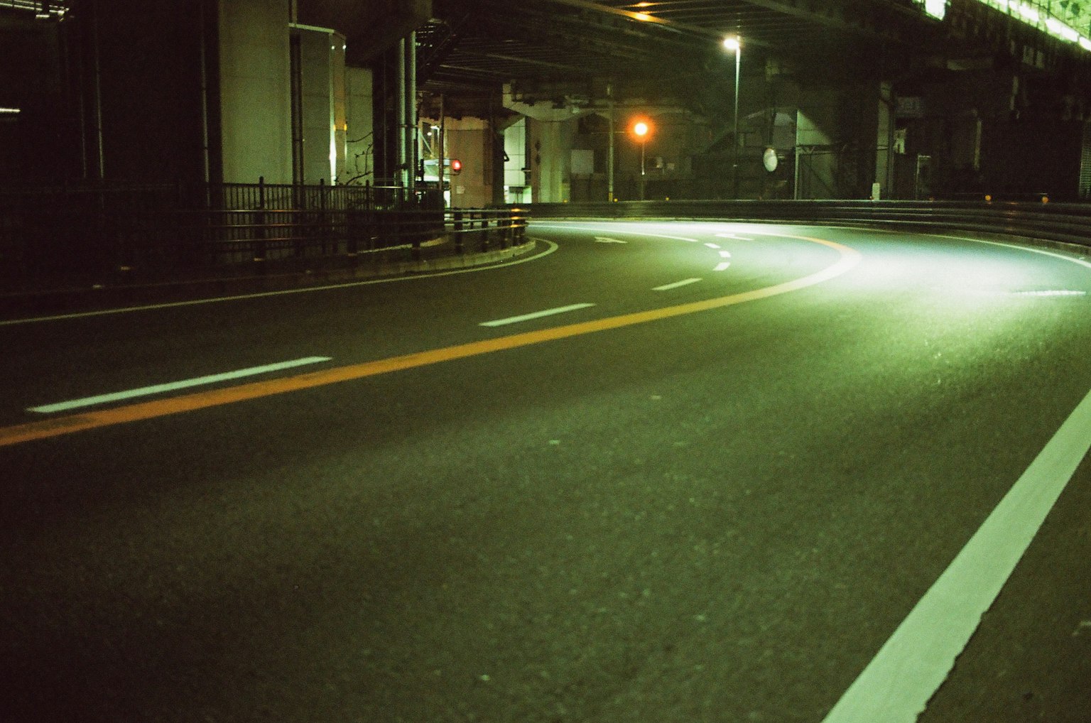 Route nocturne courbe avec des lampadaires et un sol lumineux