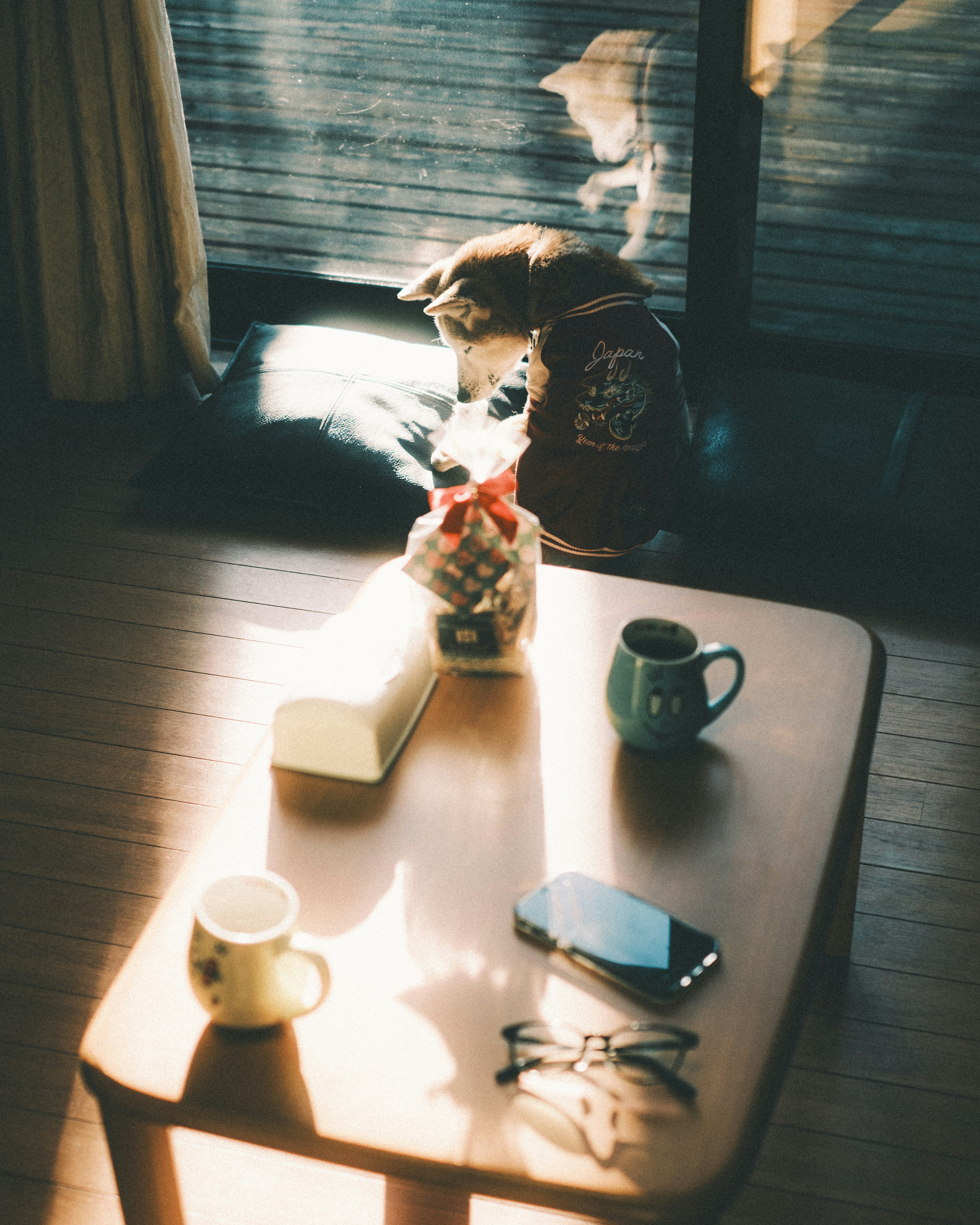 窓辺のテーブルでコーヒーとスマホを置く室内の静かなひととき