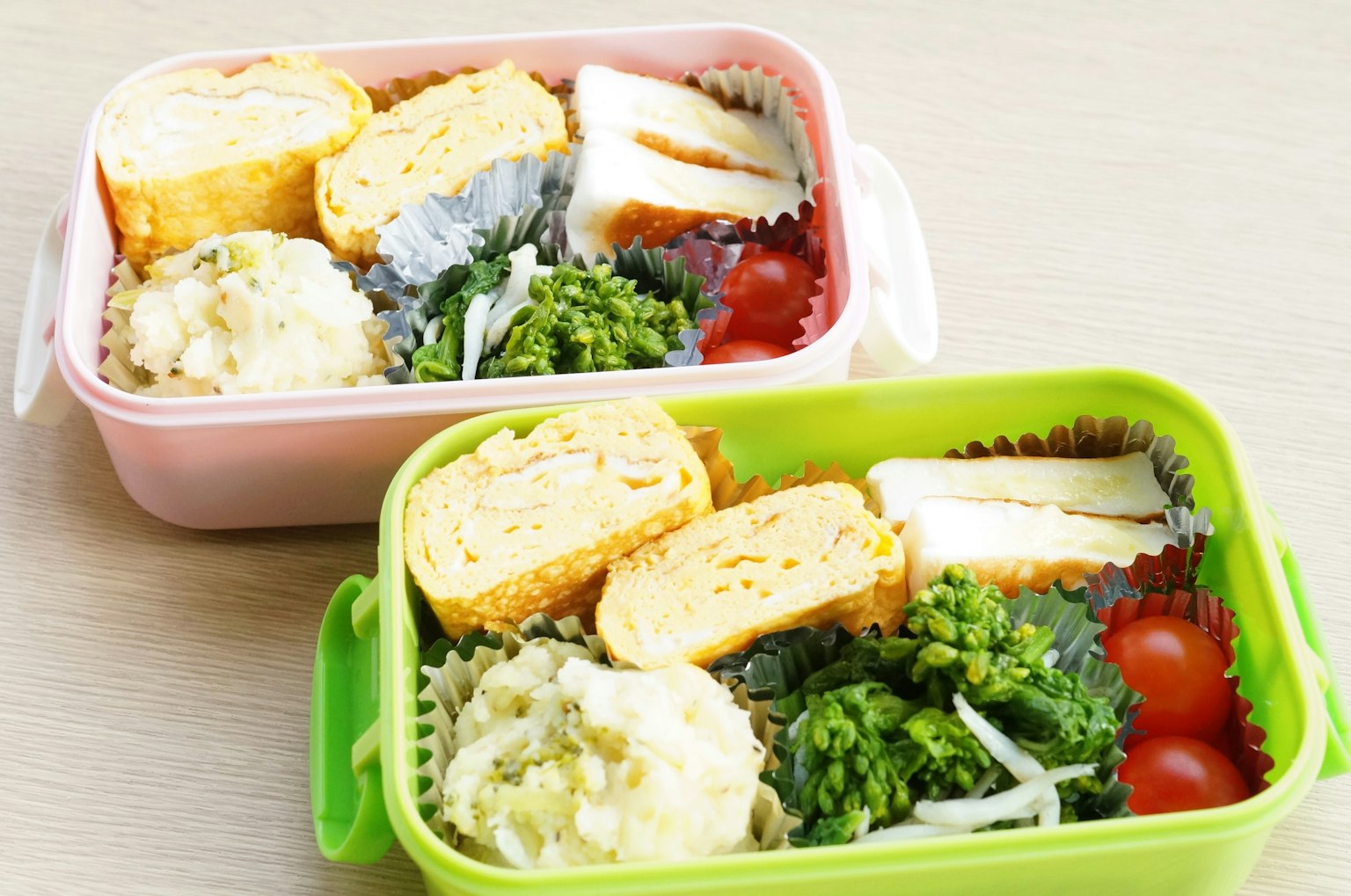 핑크와 녹색의 두 개의 도시락 상자에 담긴 맛있는 음식