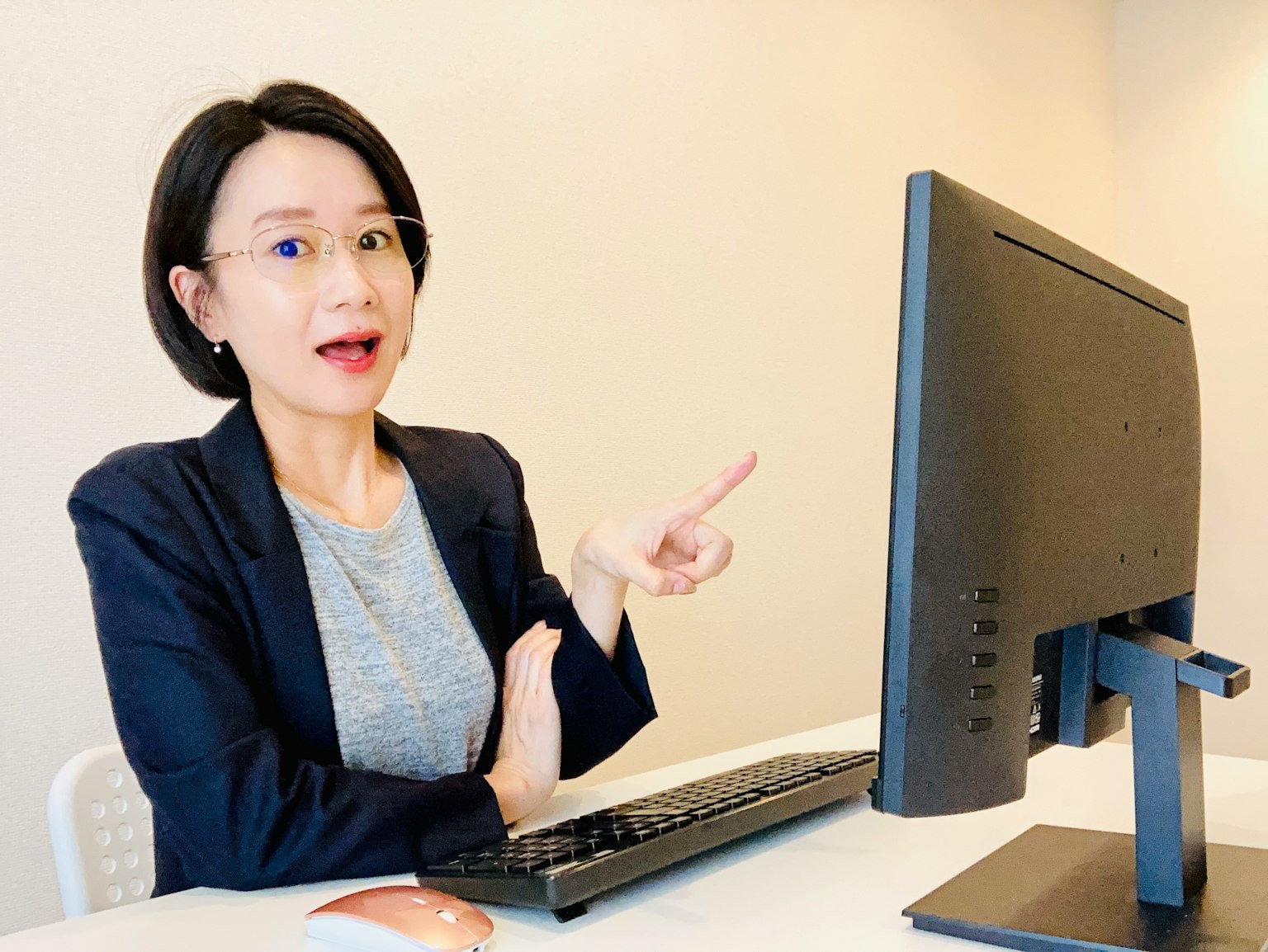 女性在现代办公室环境中指向计算机屏幕