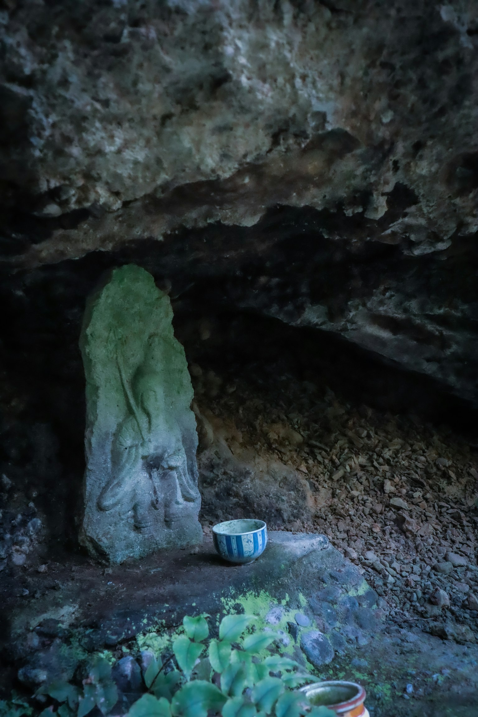 Steinskulptur und Tonteller in einer Höhle