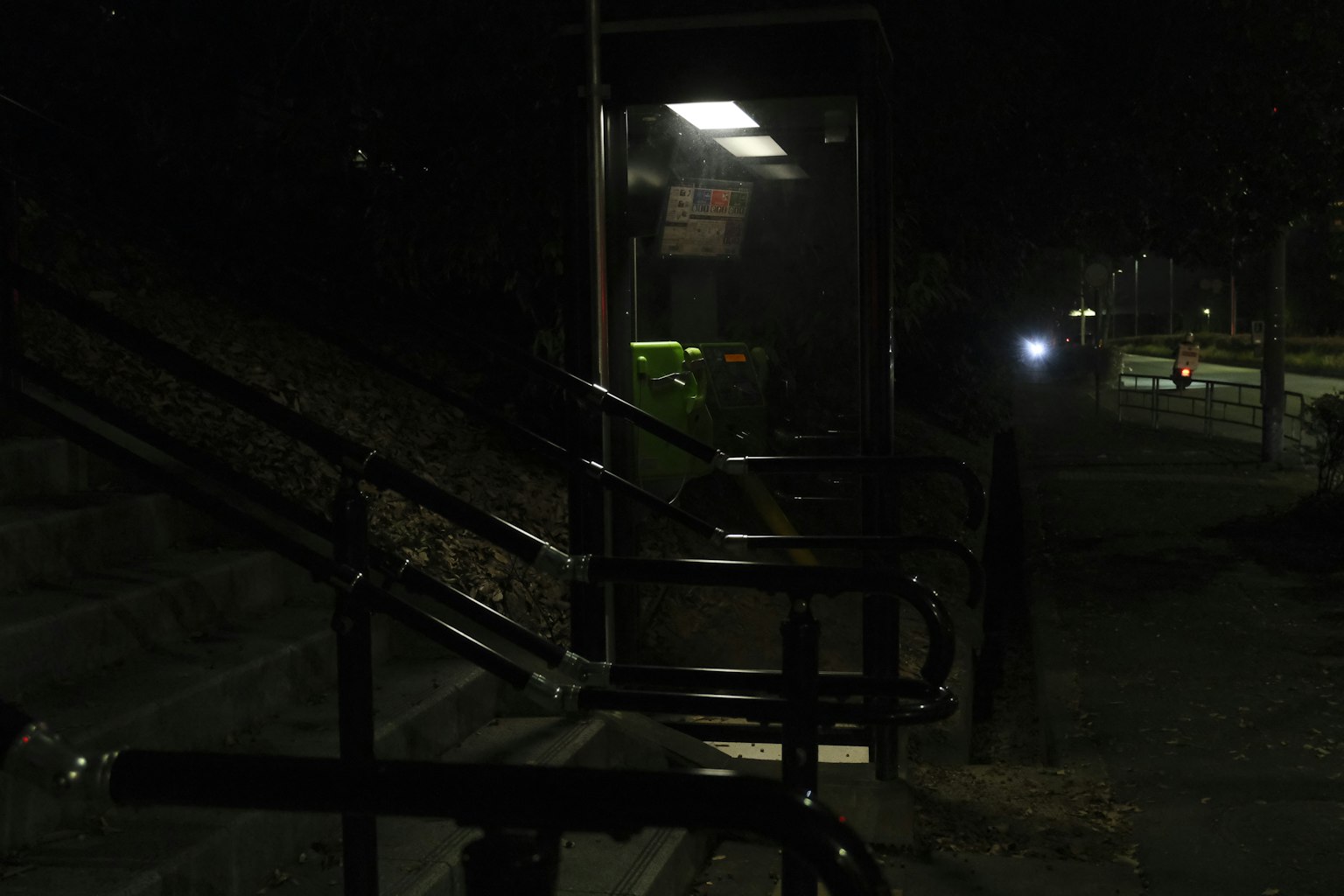 Escena nocturna de una cabina telefónica y escaleras