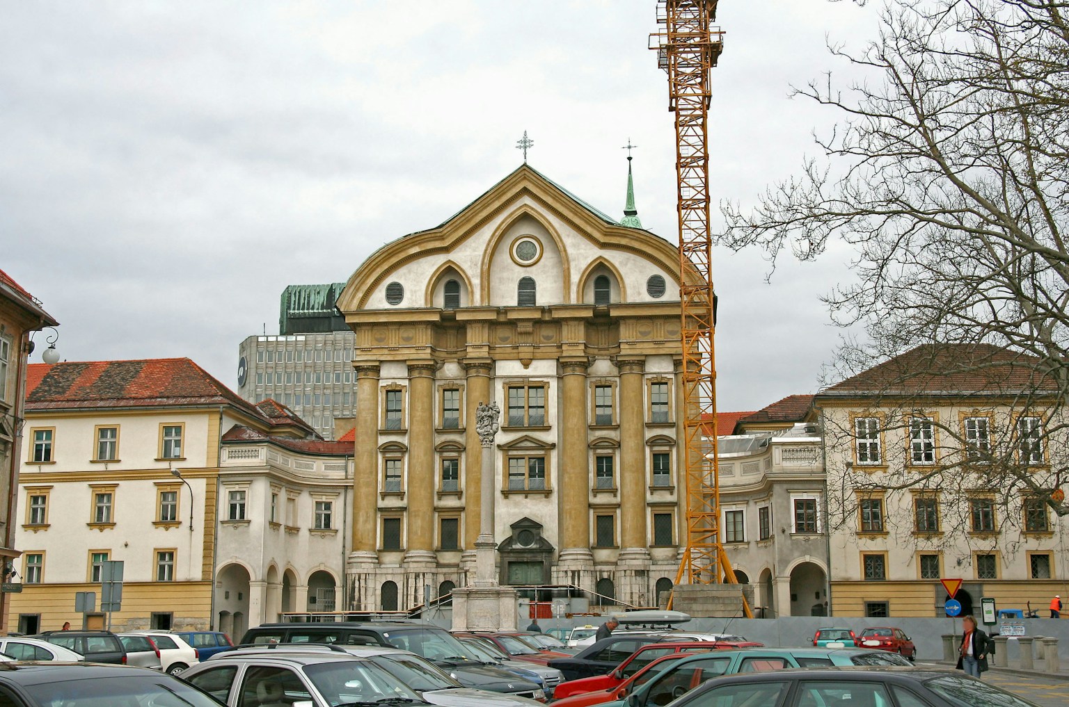 Historic building with a parking lot in front and a crane in the background