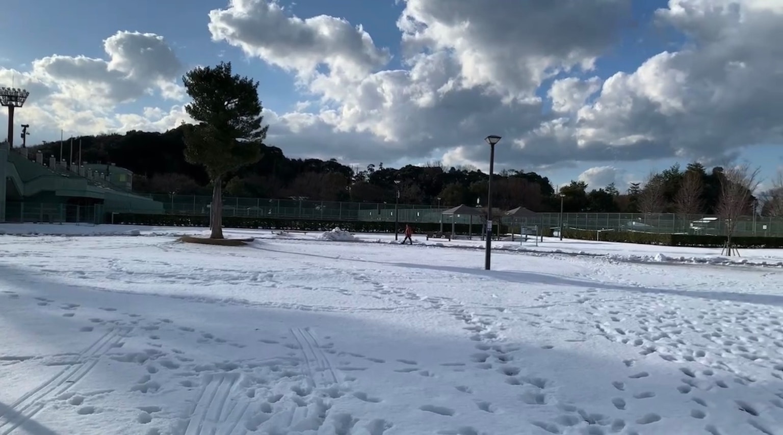 Champ recouvert de neige avec des nuages dans un ciel bleu