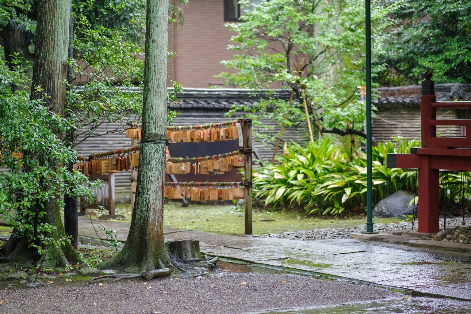 Lush garden with trees and traditional building in the background