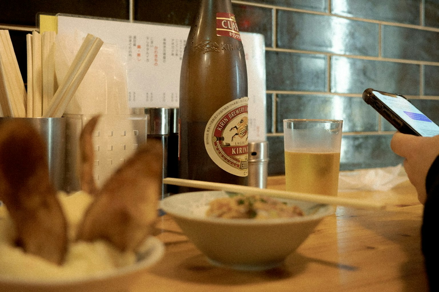 Table setting with Japanese dishes, sake bottle, and beer