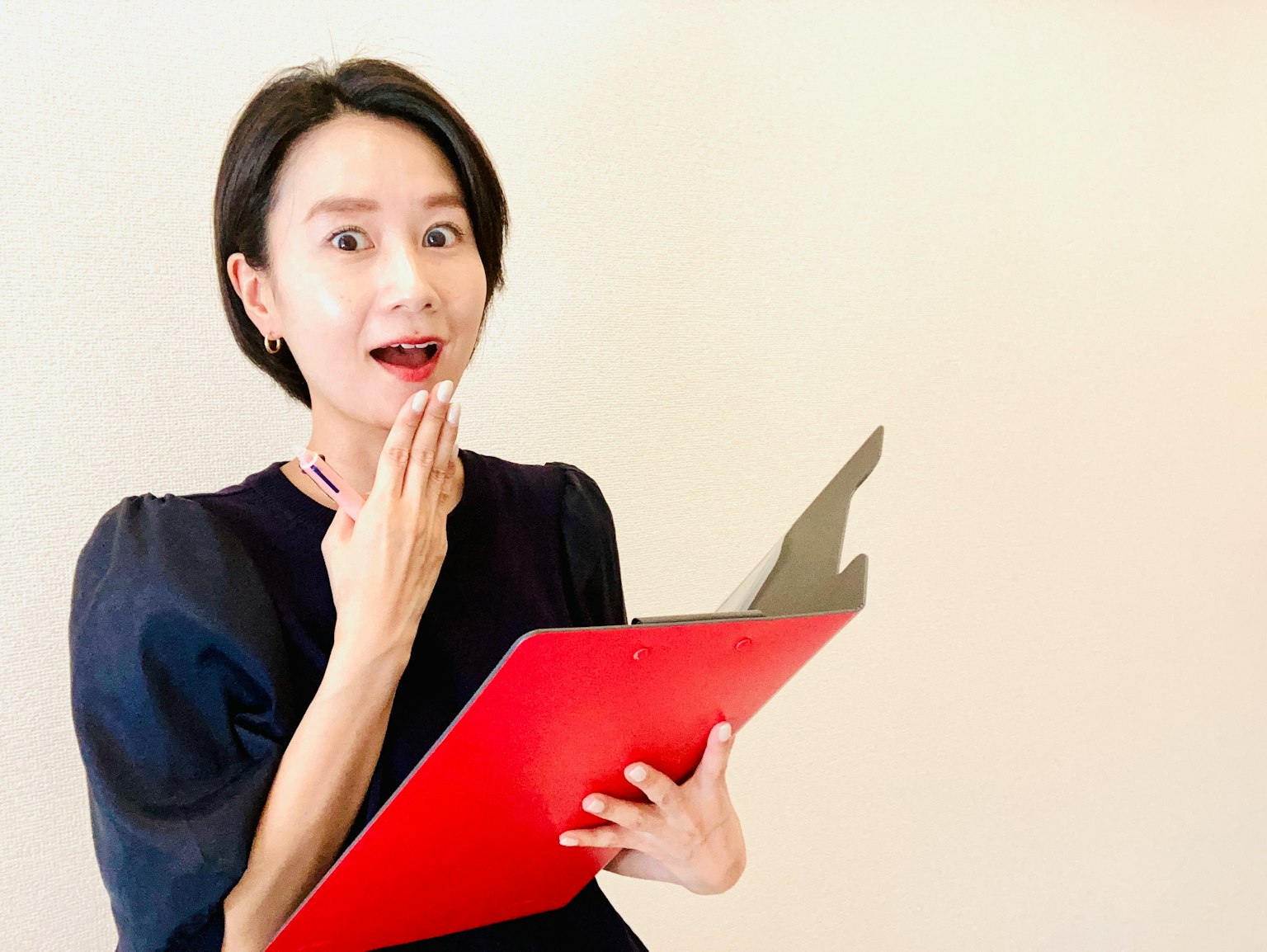 Người phụ nữ ngạc nhiên cầm bảng kẹp màu đỏ