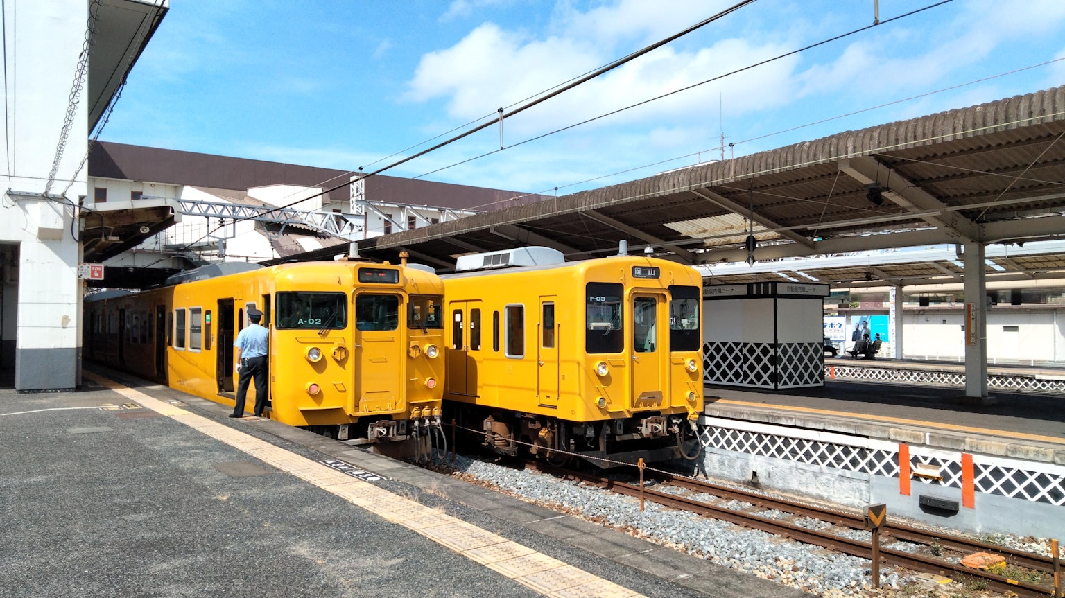 藍天下車站停靠的黃色列車