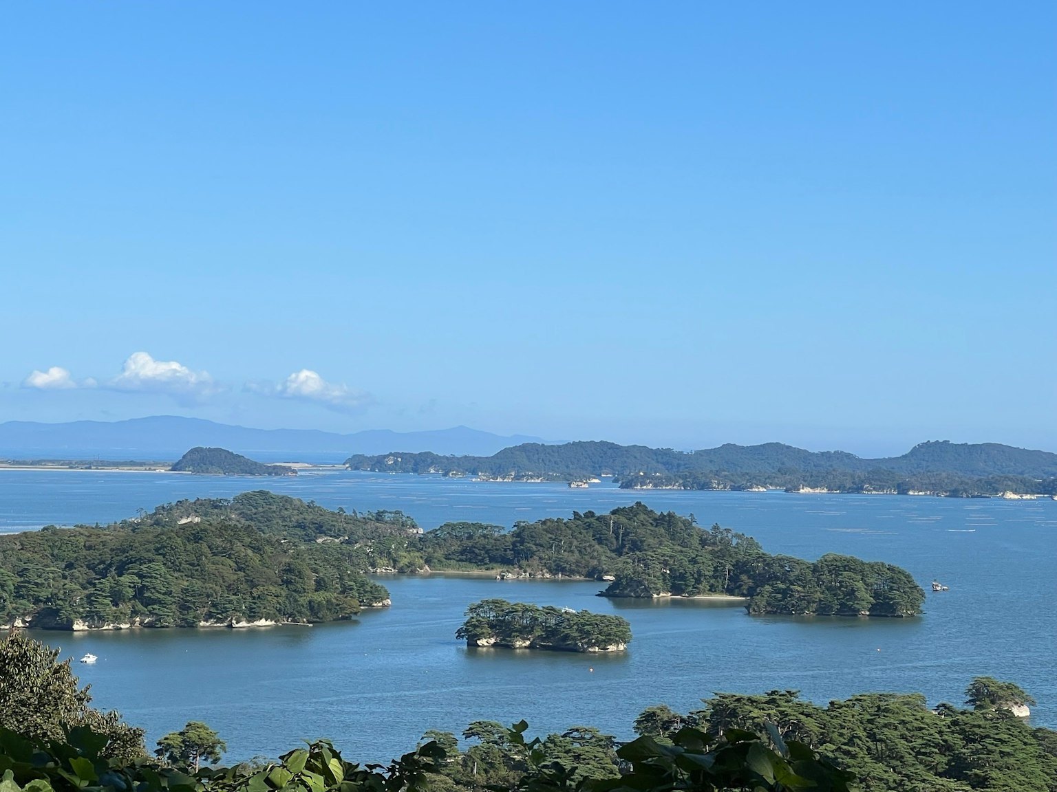 Scenic view of small islands scattered in calm blue waters under a clear sky