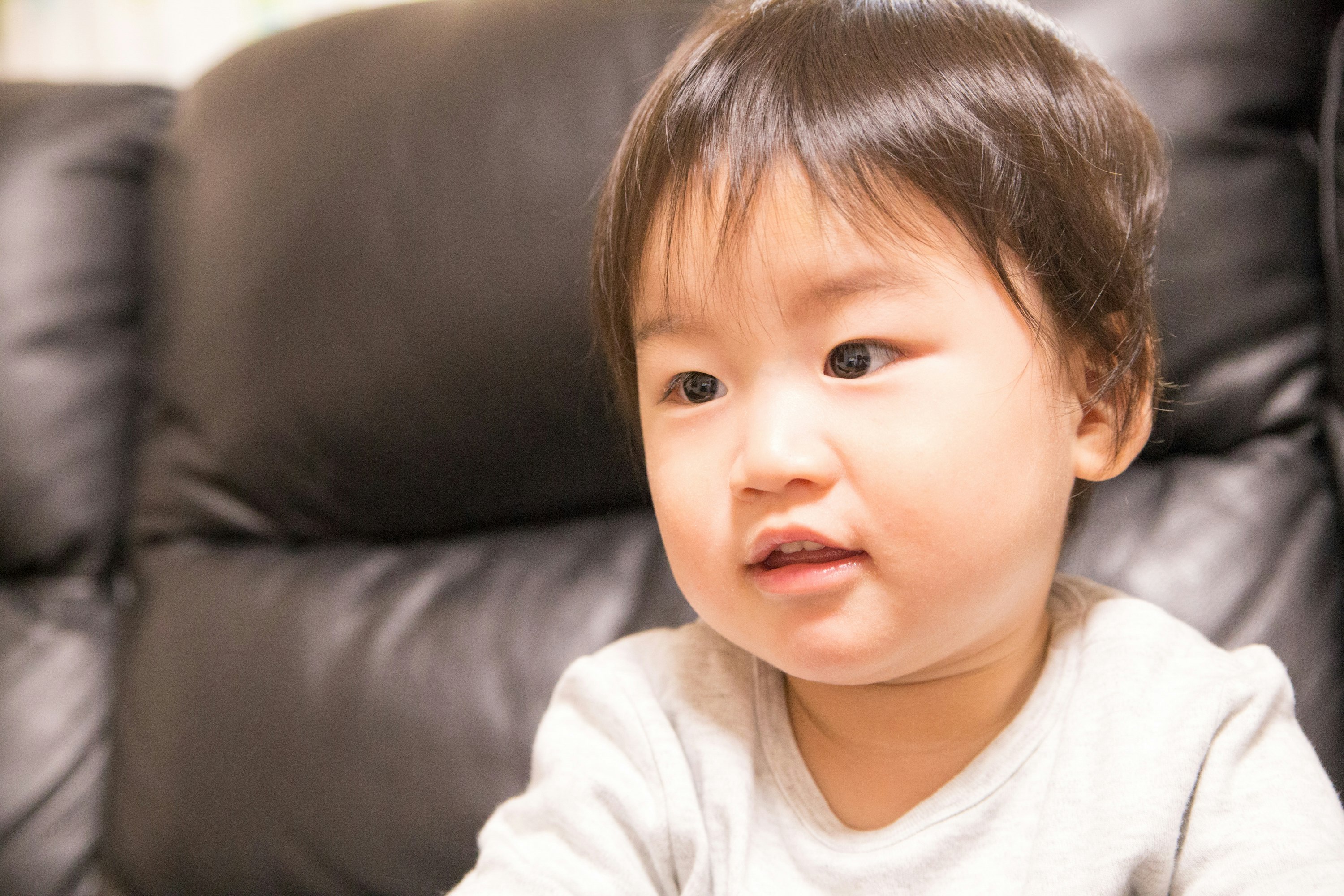 ソファに座る赤ちゃんの穏やかな表情