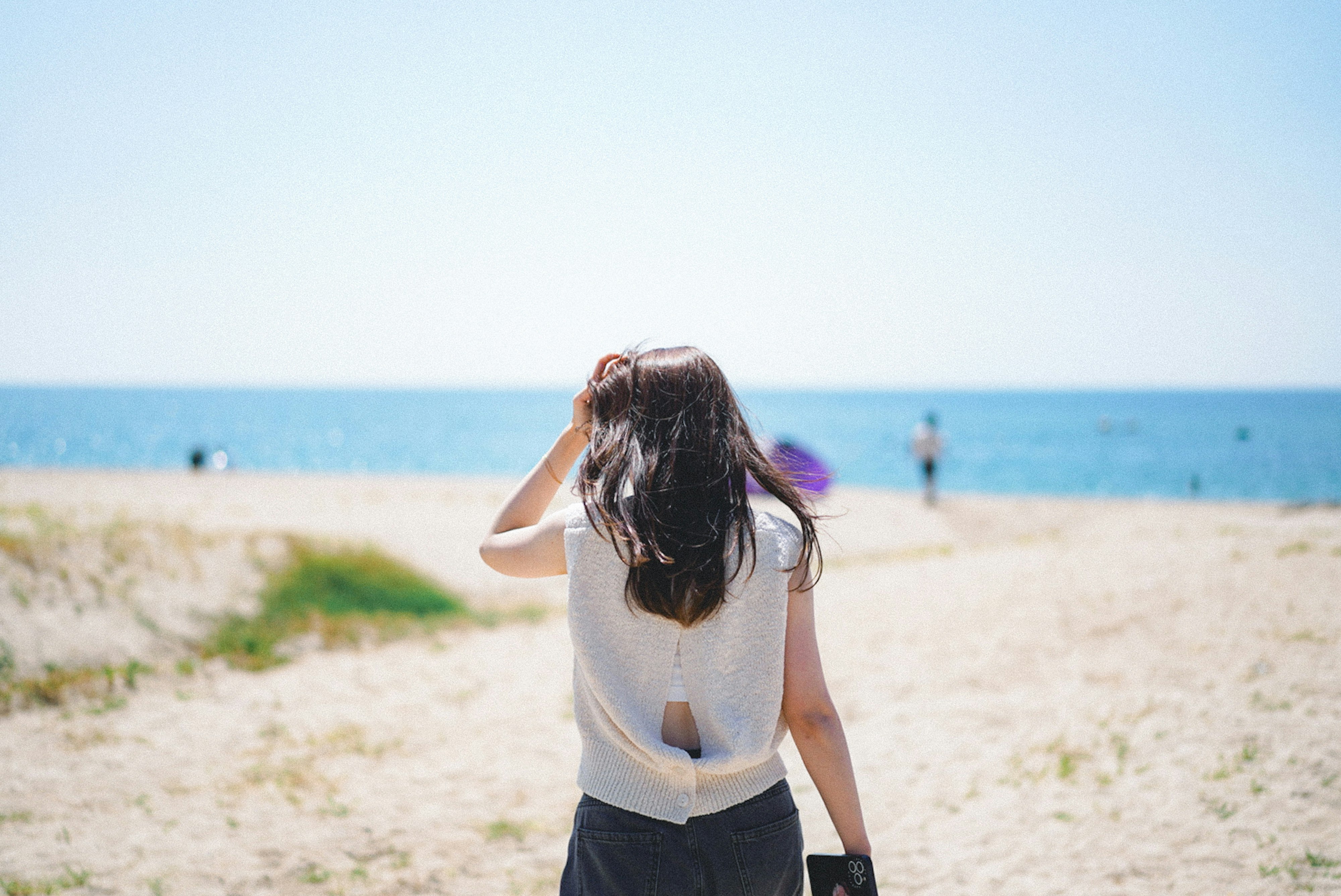 海辺を歩く女性の後ろ姿