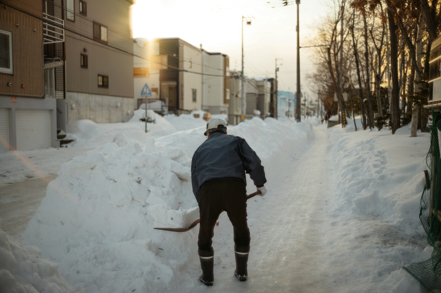 Hombre quitando nieve en una calle cubierta de nieve