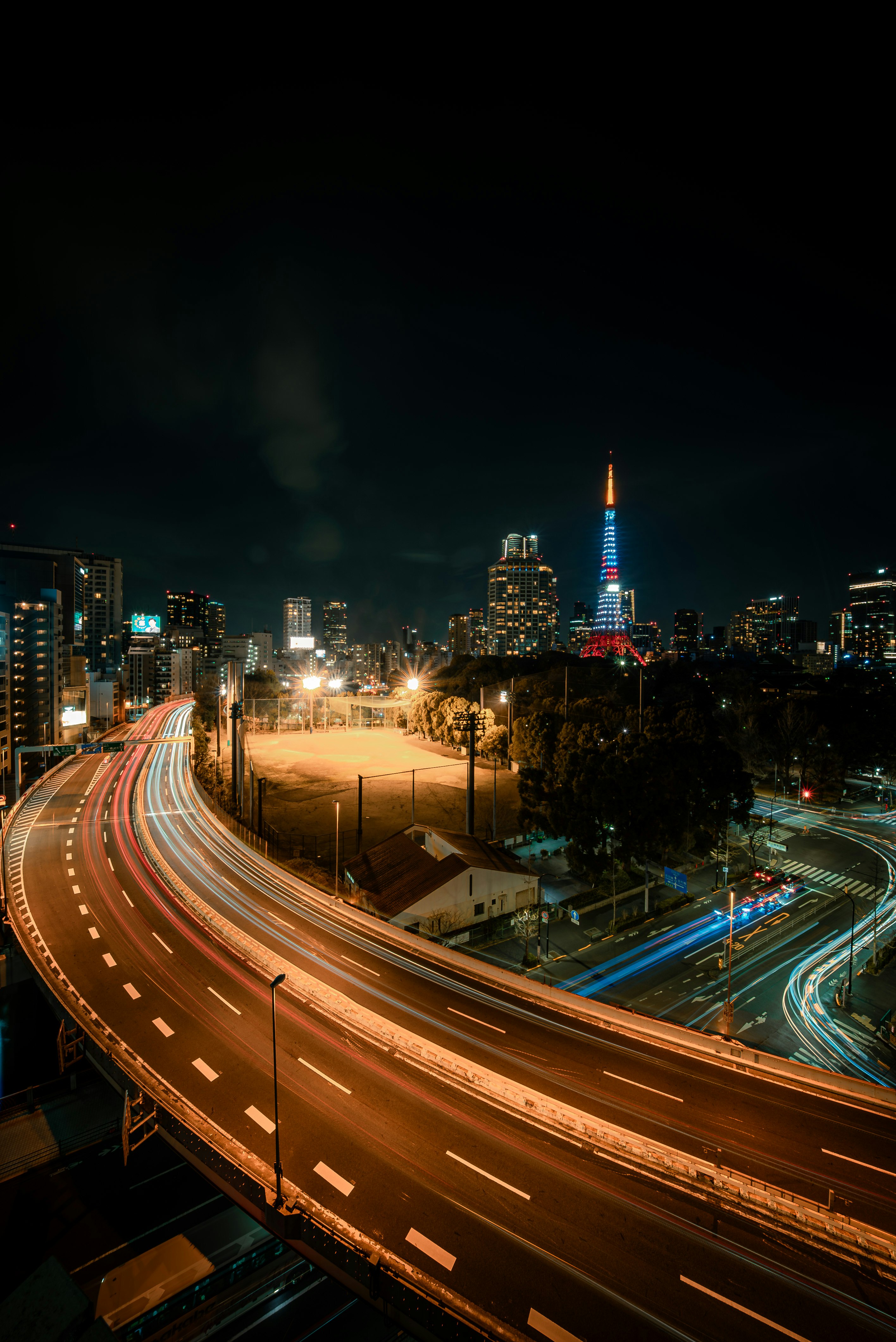 夜の高速道路と都心の夜景を見下ろす眺め
