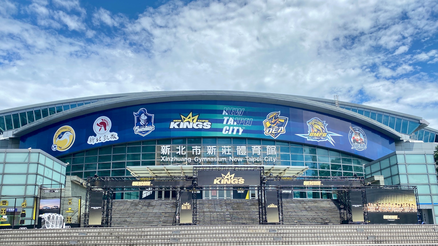 Exterior view of a sports arena featuring large banners and stairs