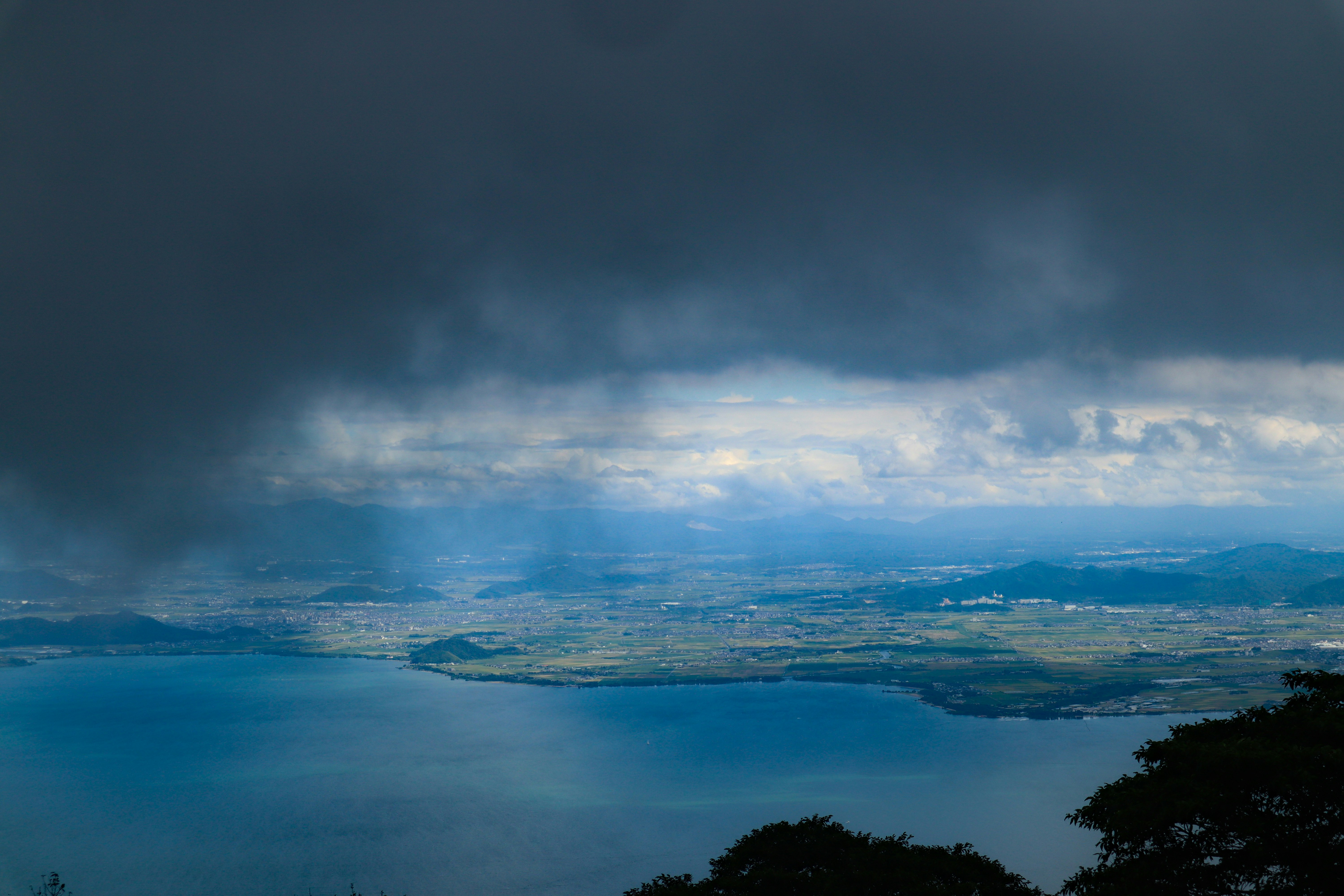 琵琶湖に向かって広がる雨雲と空の山歩き風景