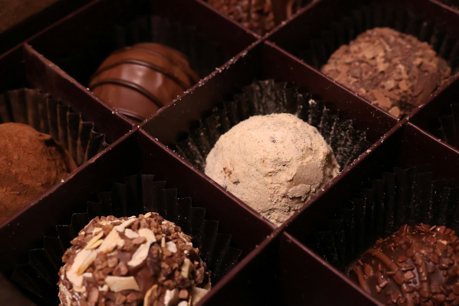An assortment of chocolate truffles arranged in a box with different flavors and textures