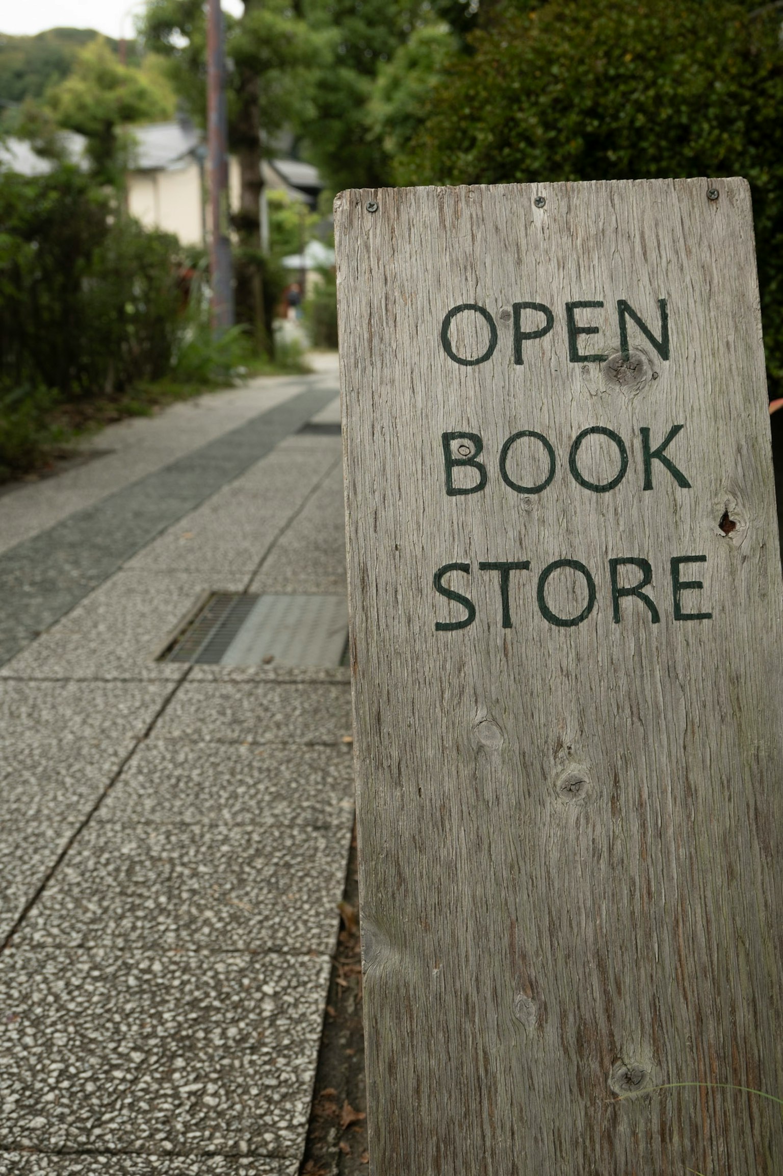 Cartello in legno che indica una libreria aperta in una strada tranquilla