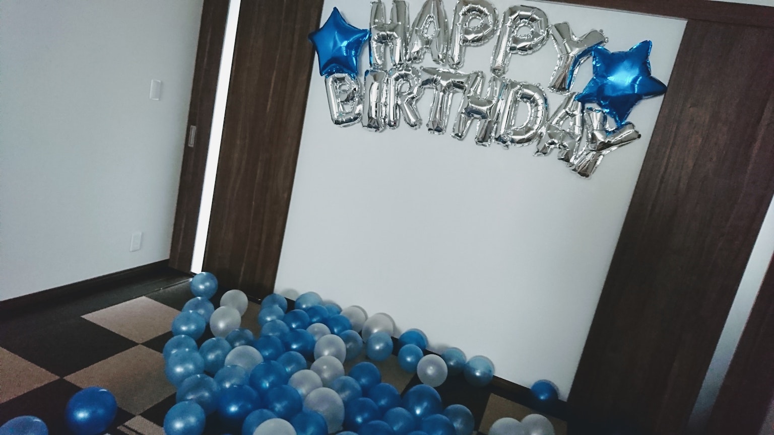 Décoration d'anniversaire avec des ballons bleus et des ballons argentés écrivant Joyeux Anniversaire