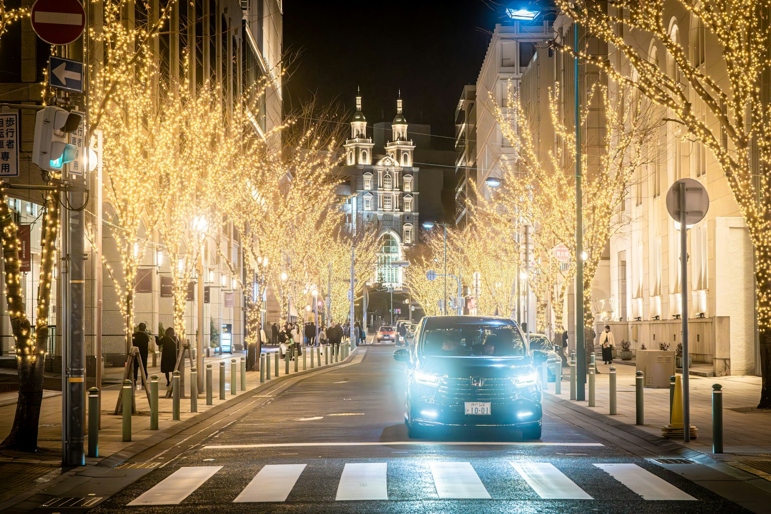 Une rue illuminée de lumières la nuit avec une voiture et des bâtiments