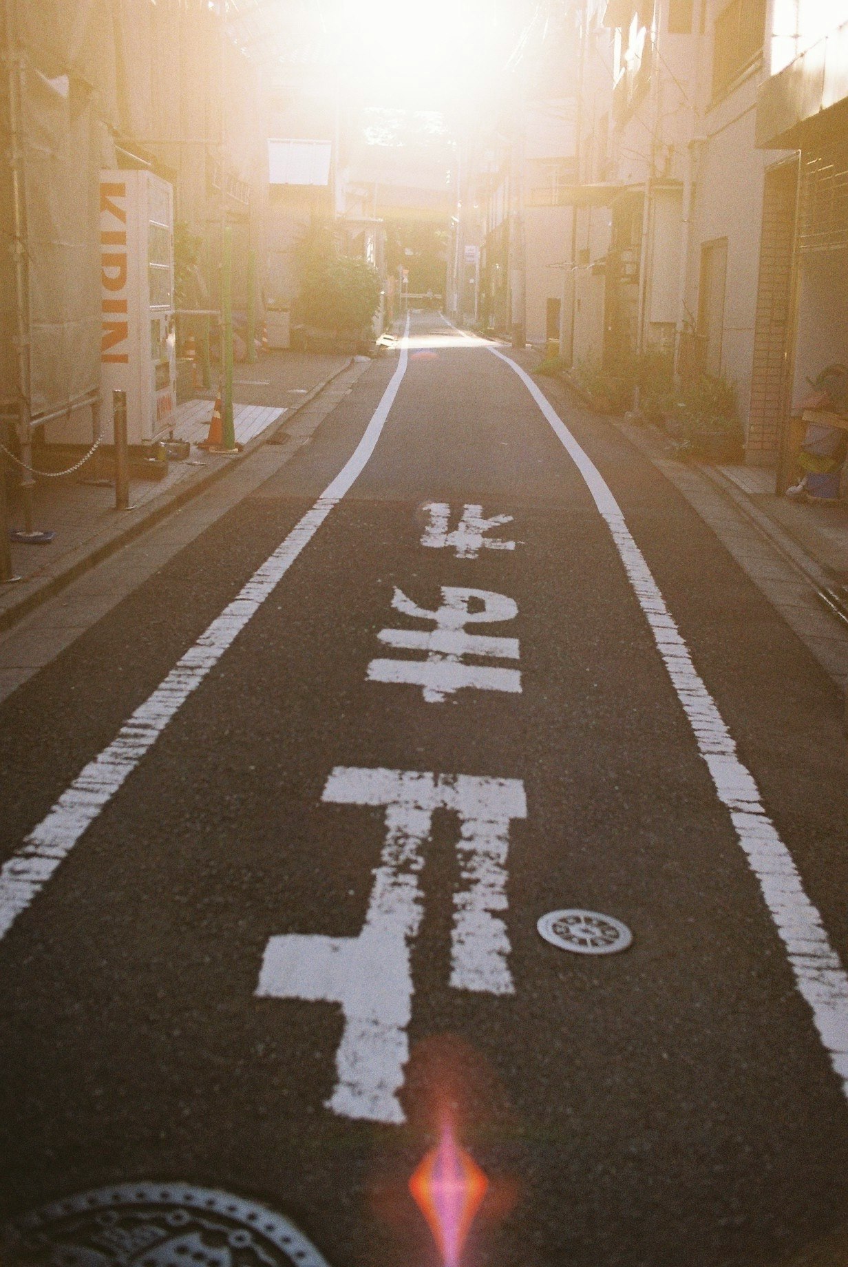 路地に並ぶ看板と自転車のある商店街の夕方の通り