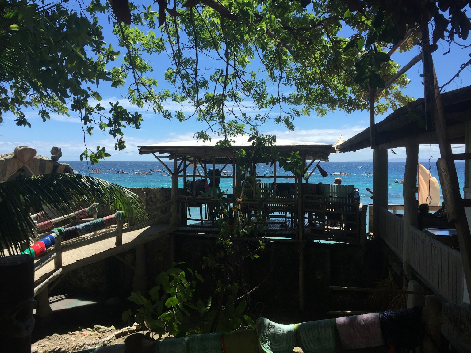 Malersiche Aussicht auf eine Strandhütte umgeben von grünen Bäumen und blauem Ozean