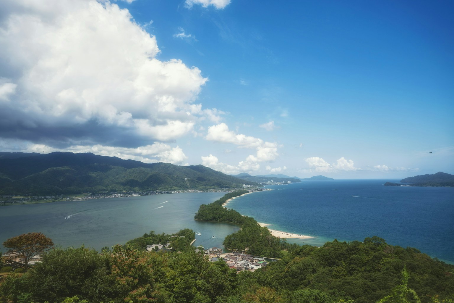 青い空と雲が広がる海の景色 確かな陸地と島々が見える