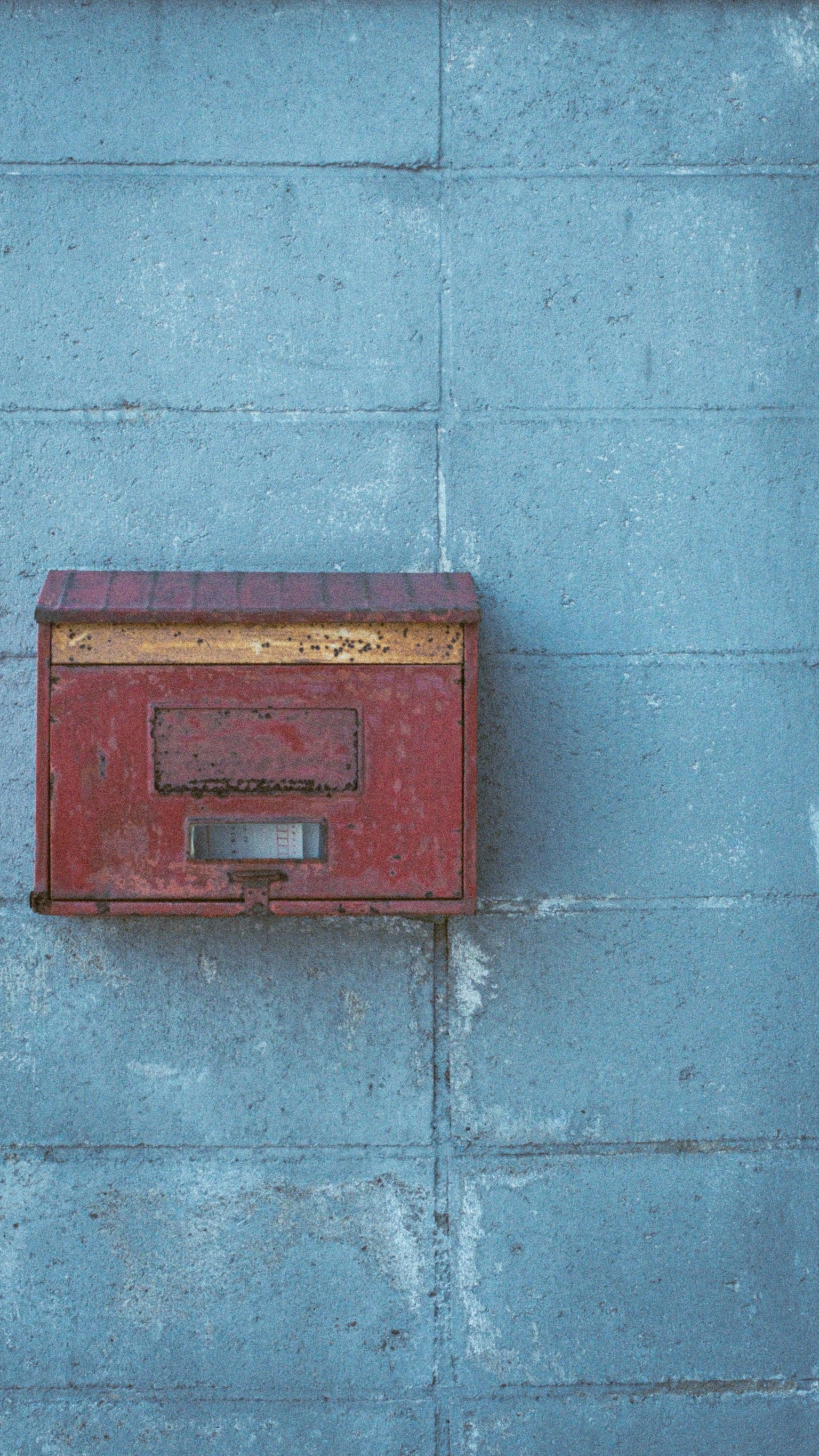 Cassetta postale rossa montata su un muro blu