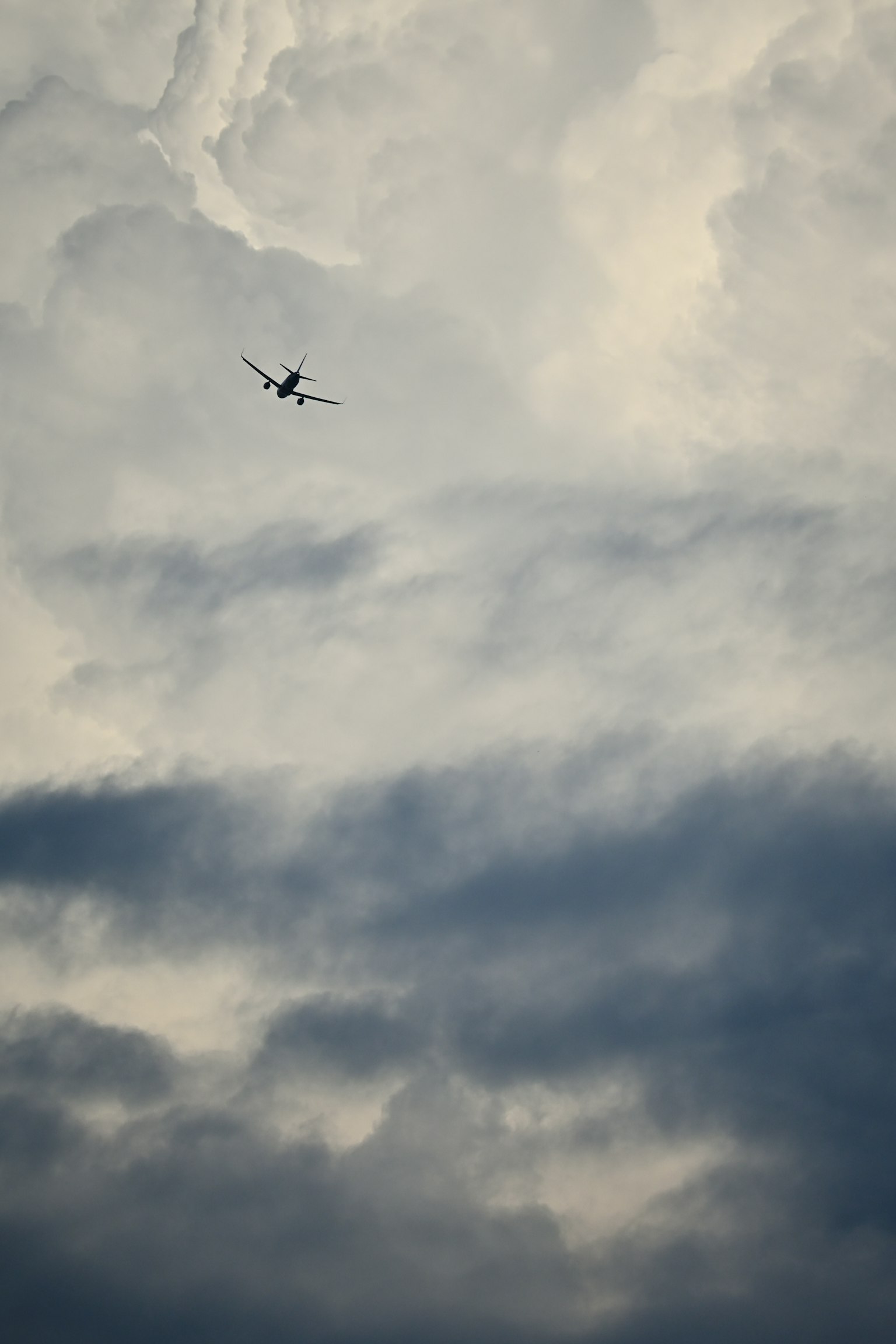 Silueta de un avión volando entre las nubes