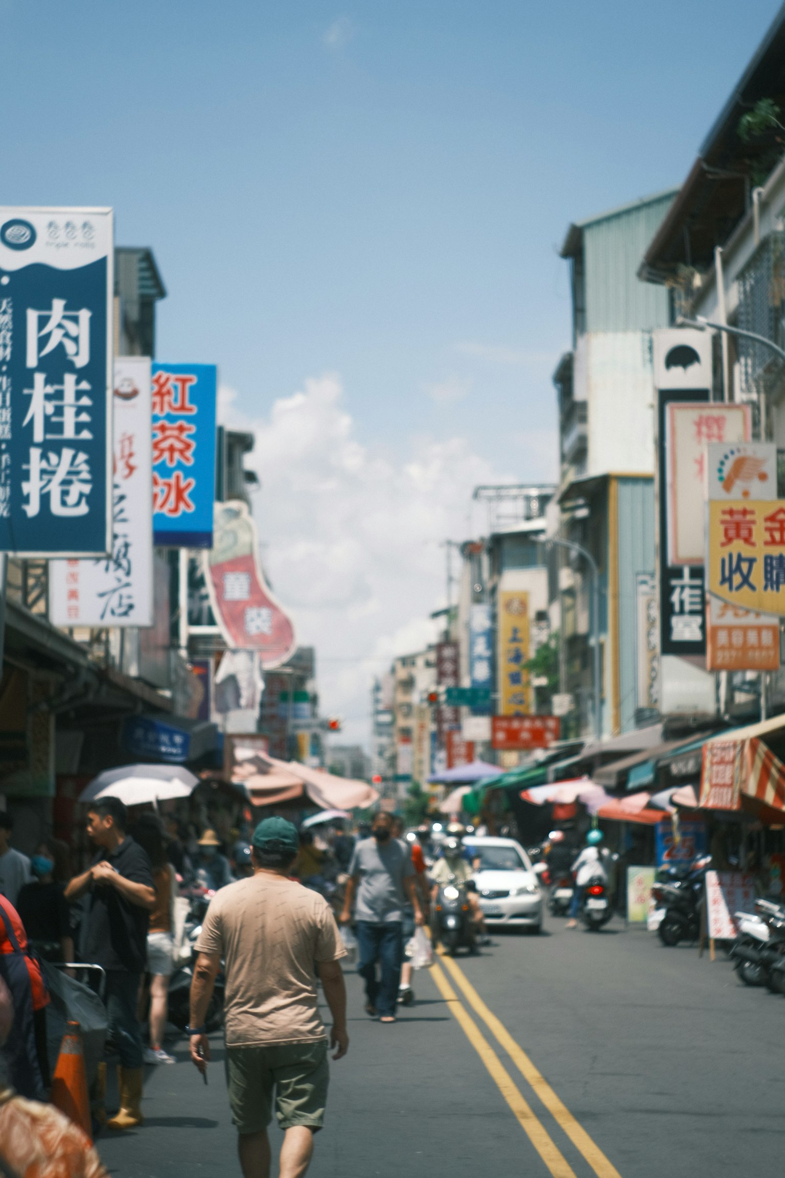 Belebter Straßenmarkt mit Menschen, die gehen verschiedene Schilder und Stände entlang der Straße