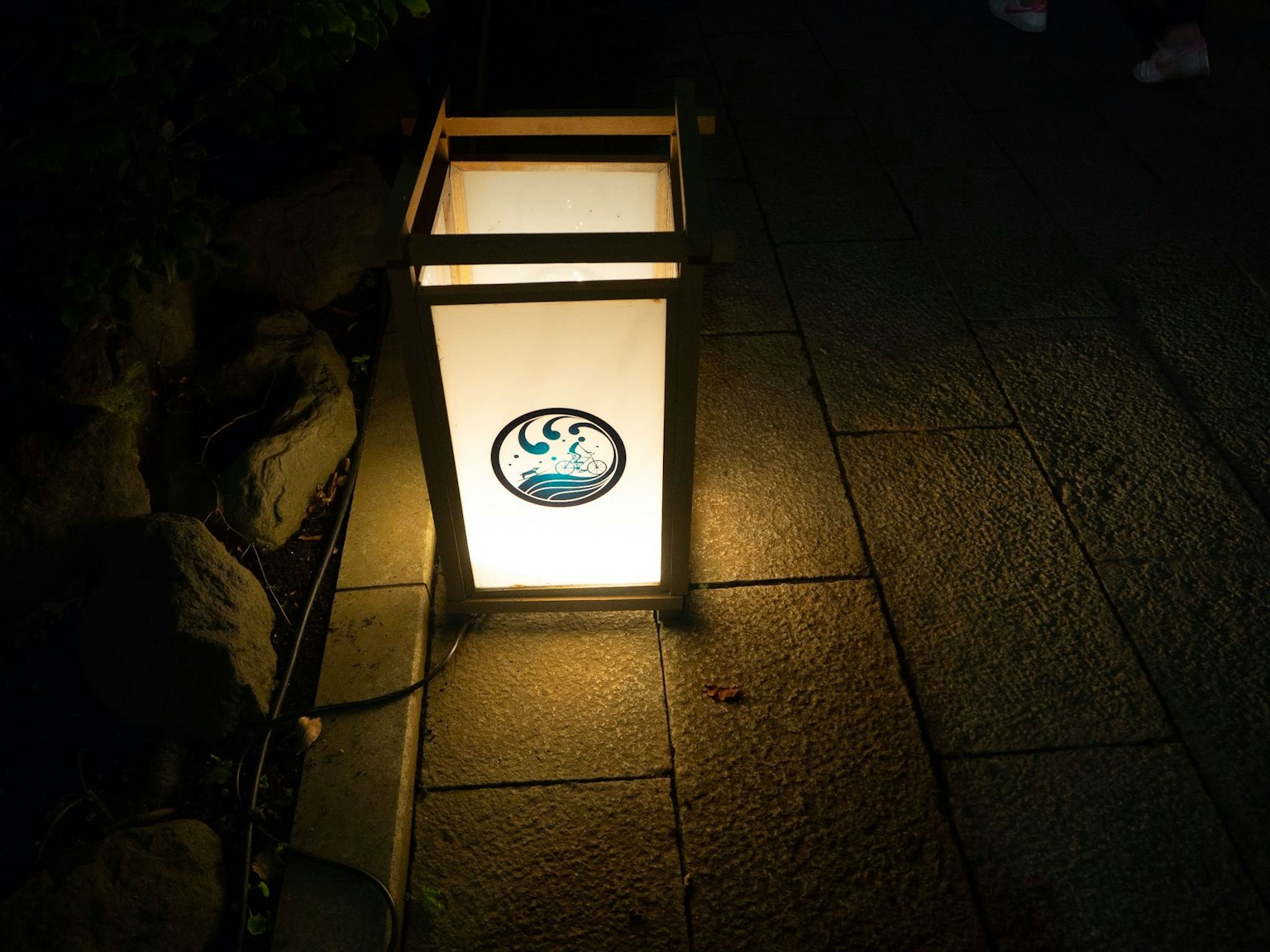 Japanese lantern illuminating a stone pathway at night