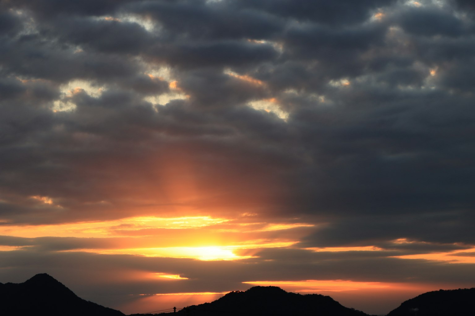Hermoso atardecer con rayos de luz que atraviesan las nubes