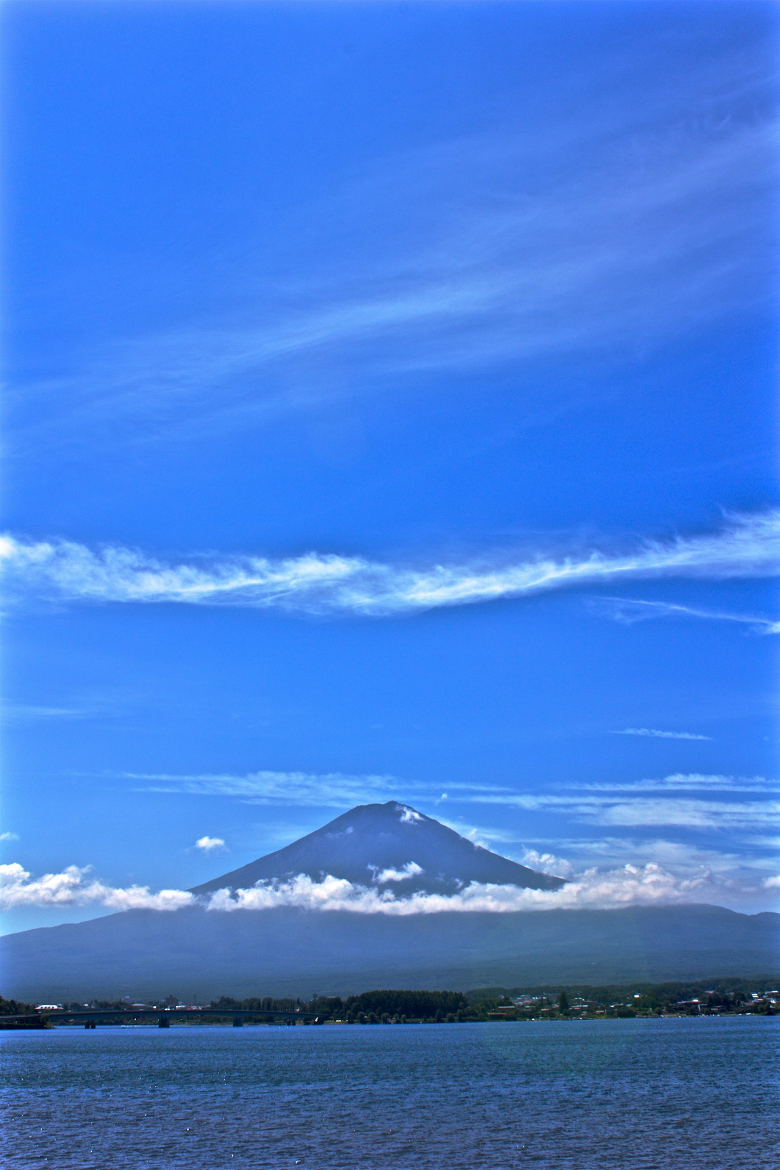 Vista panoramica di una montagna circondata da cielo blu e nuvole bianche