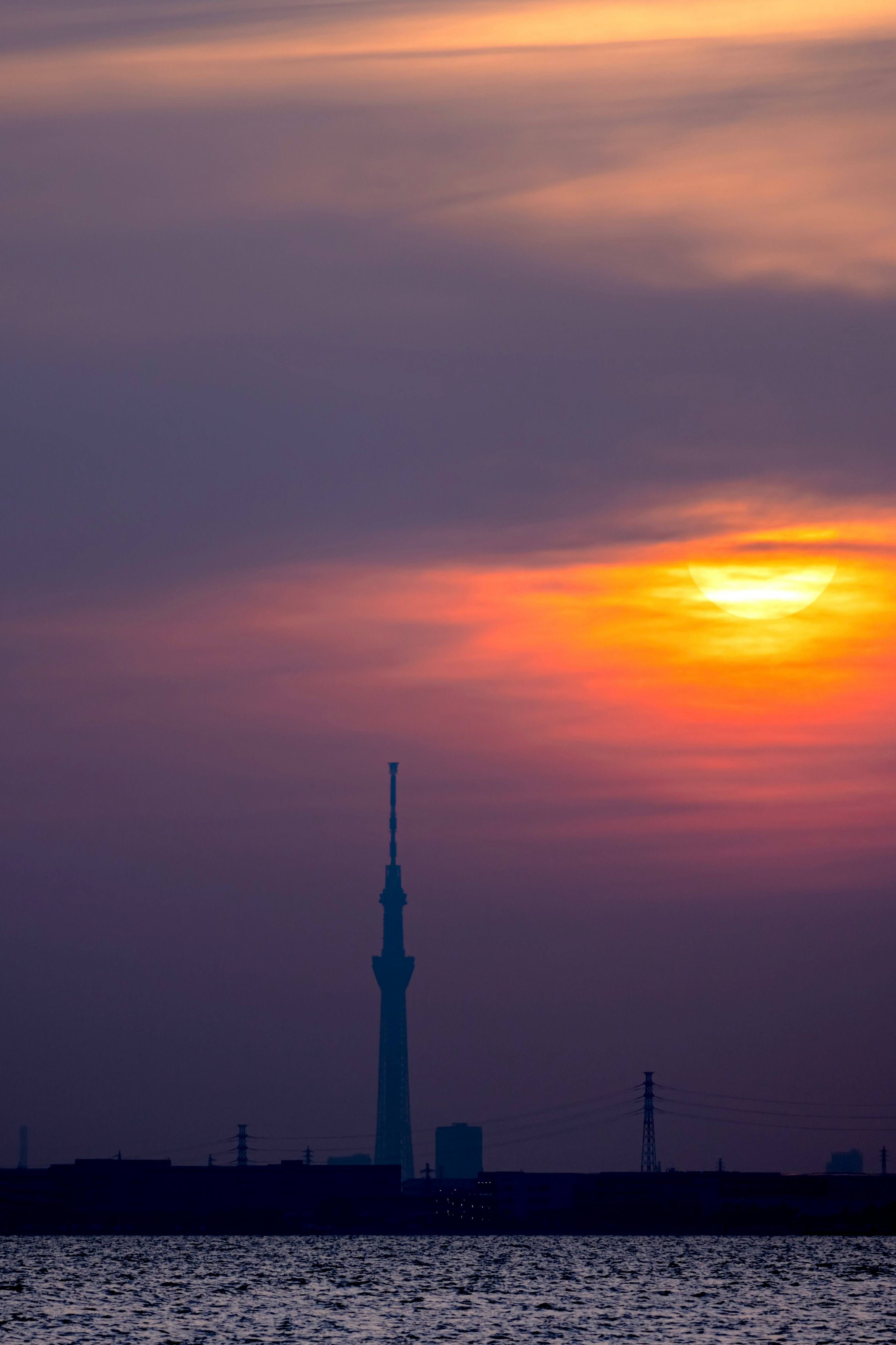 langit senja di atas sungai dengan siluet menara