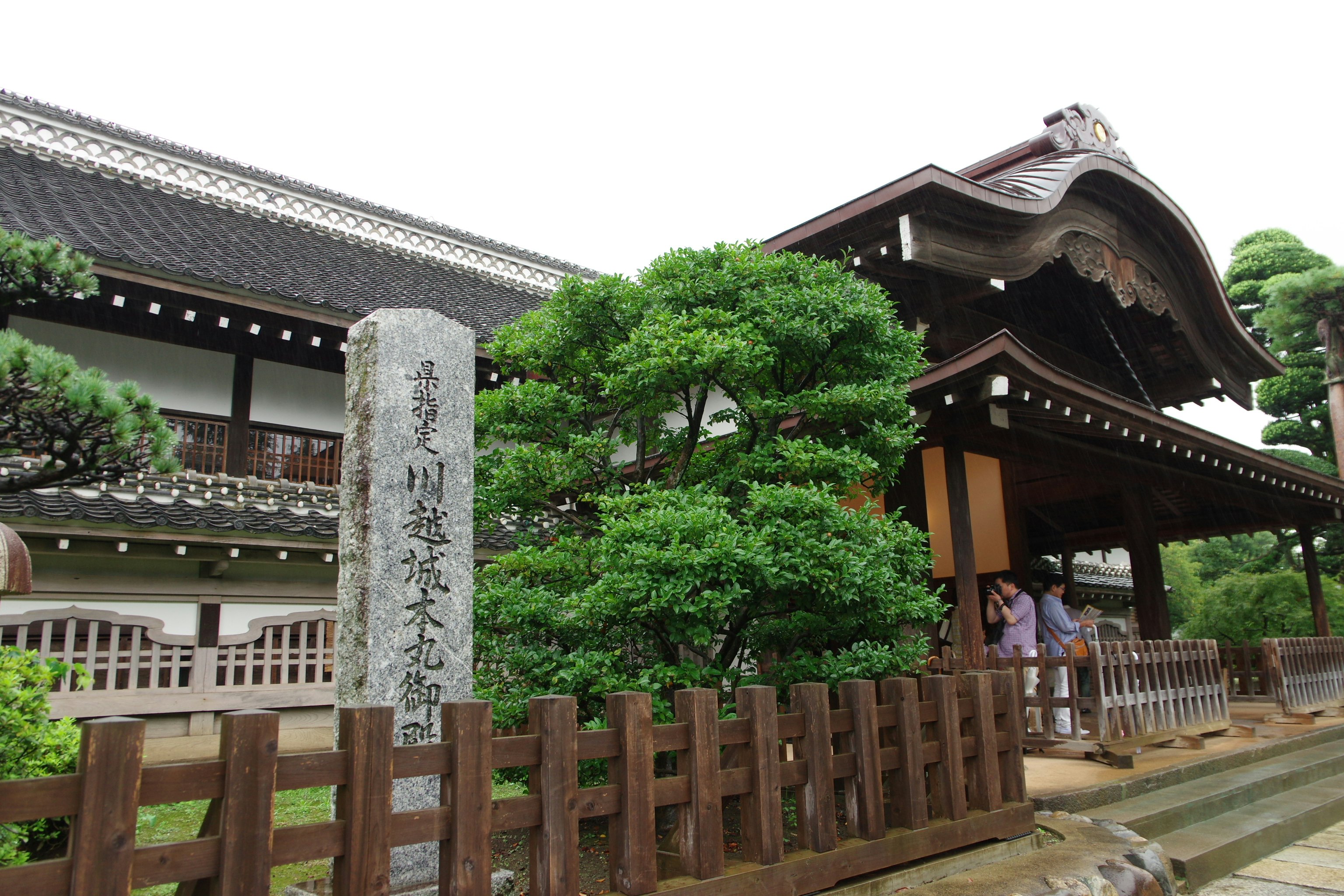 寺廟鐘樓與花園柵欄，茂密的綠樹景致